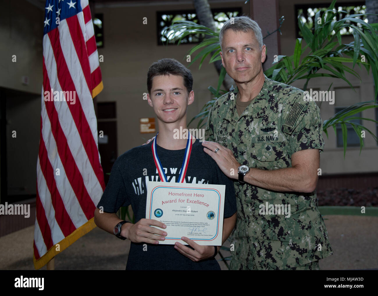 180426-N-ND 356-0080 Pearl Harbor (Apr. 26, 2018) - ein Homefront Hero Award Empfänger erhält eine Urkunde von Kapitän Jeff Bernard, Kommandeur der Joint Base Pearl Harbor-Hickam, während der Homefront Held Zeremonie Zeremonie an einem militärischen und Family Support Center unter Joint Base Pearl Harbor-Hickam. Die Homefront Hero Award wurde in einer Unterstützung der Monat der militärischen Kind erstellt. (U.S. Marine Foto von Mass Communication Specialist 3. Klasse Jessica O. Blackwell) Stockfoto