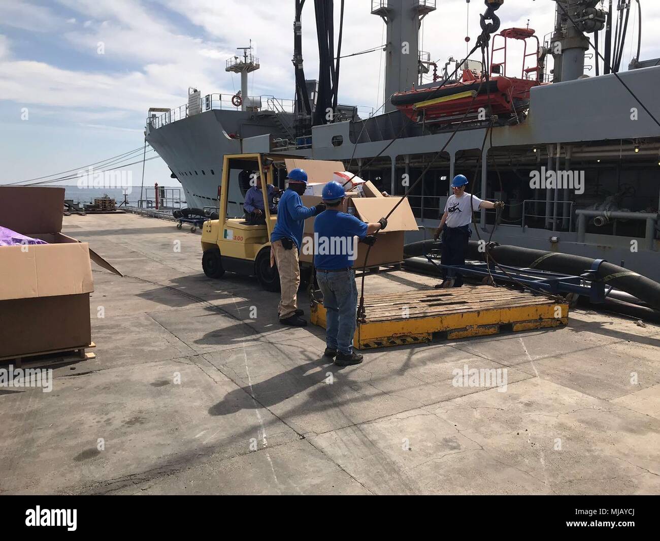 USNS Patuxent (T-AO 201) Besatzungsmitgliedern und einem Auftragnehmer von multinationalen Logistics Services (MLS) Last Post auf den Boom. Die Mail wird an Bord gehoben werden, per Schiff getrennt, und geliefert an warfighter während des nächsten geplanten Replenishment-At-Sea (RAS). Dieses Bild zeigt die NAVSUP Fähigkeit zur Bereitstellung der erforderlichen Dienste der warfighter aus fremden Ländern zu unterstützen. Stockfoto