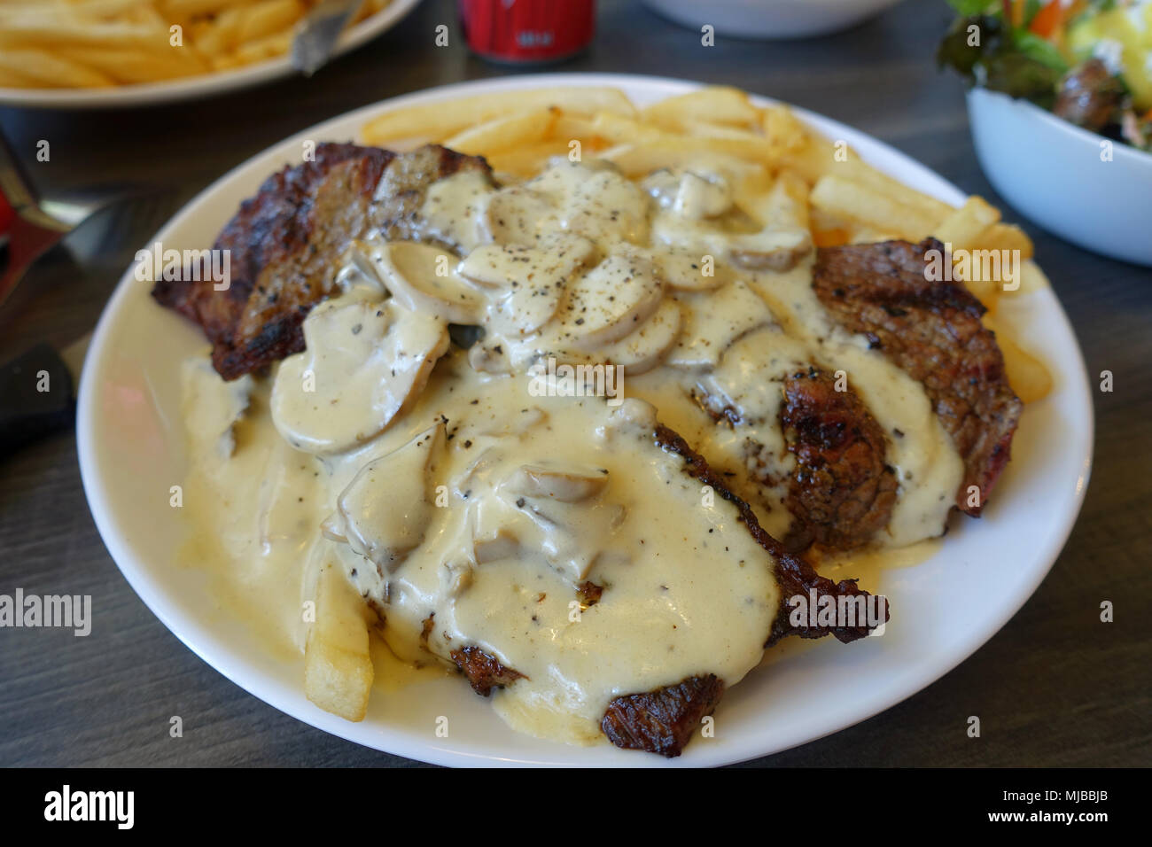 Steak und Chips mit cremiger Pilzsauce Stockfoto