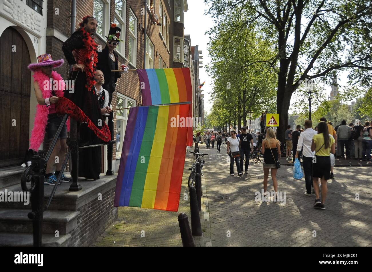 Amsterdam, Niederlande: Vier Männer in Kostümen, die auf einen Balkon, den Verzicht auf die regenbogenfahnen auf die Masse, die am traditionellen Amsterdam Gay Pride event. Stockfoto
