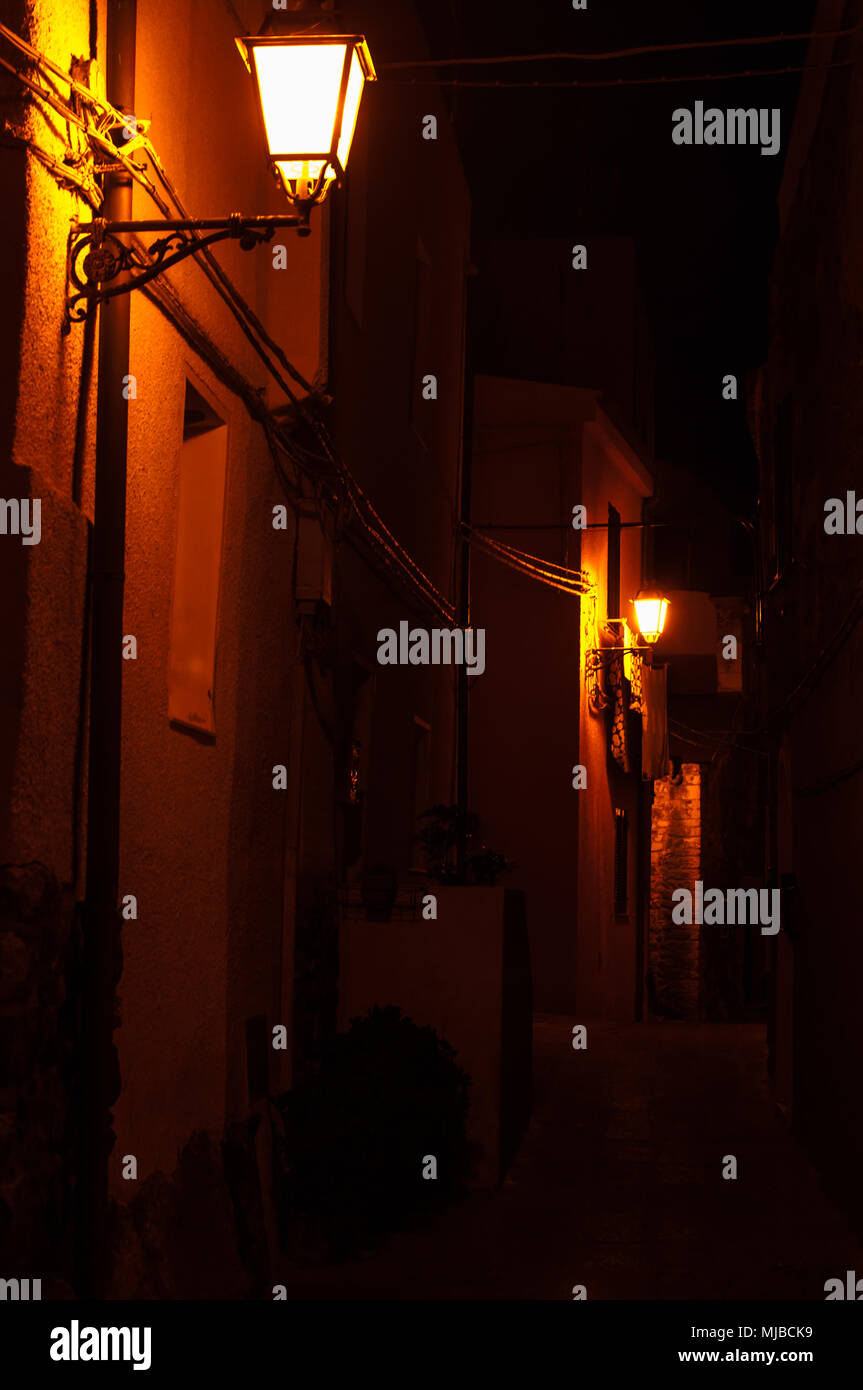 Orange Straßenbeleuchtung in einer Gasse in einem kleinen sardischen Dorf Stockfoto