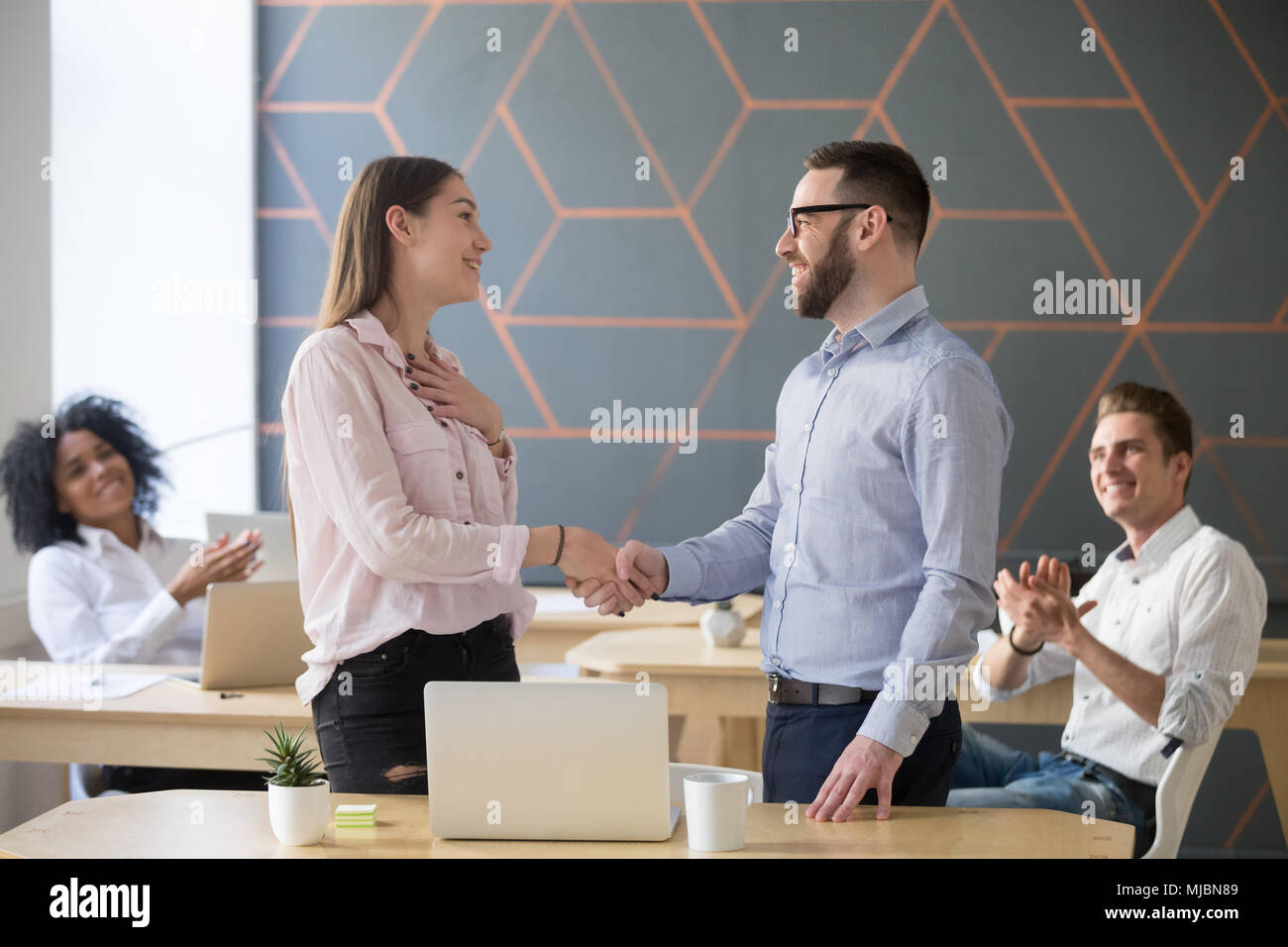 Boss handshaking erfolgreichen weiblichen Angestellten mit beglückwünschen. Stockfoto