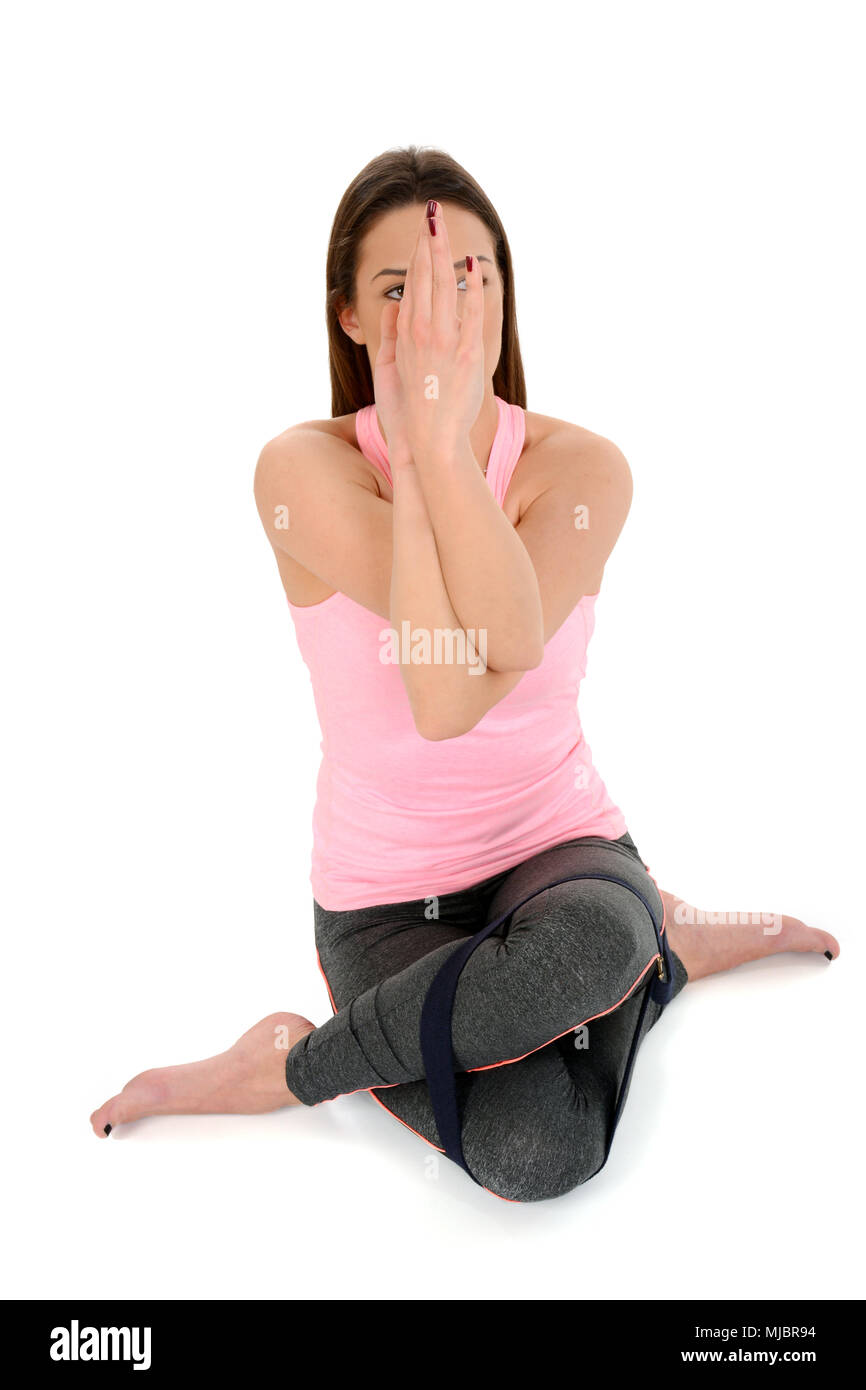 Junge Frau in Yoga position Kuh Gesicht darstellen (Gomukhasana mit Riemen). Stockfoto