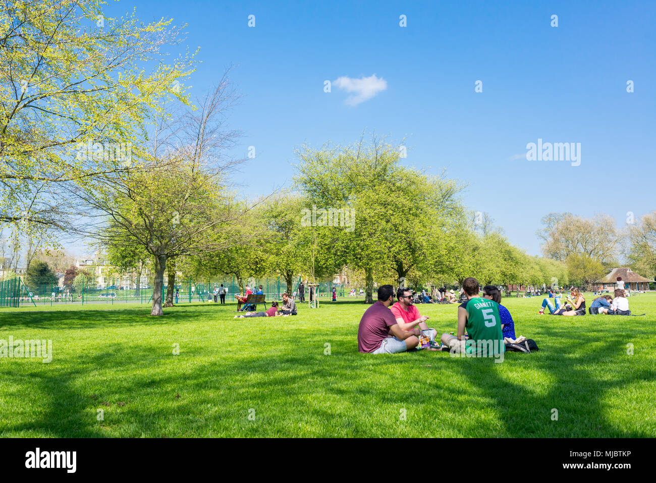 Die Menschen genießen das warme Wetter im Frühling in Jesus Green Park, Cambridge, UK. Stockfoto