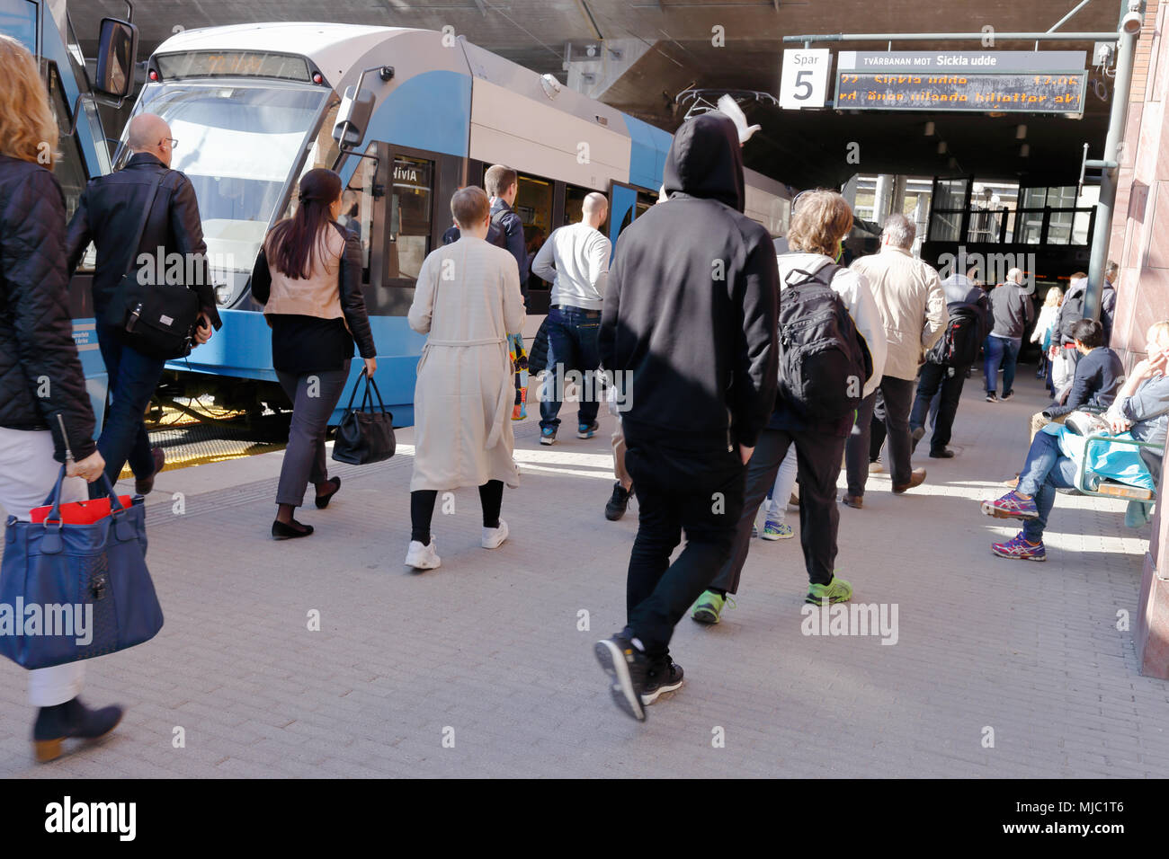 Stockholm, Schweden - 2. Mai 2016: Die Passagiere haben die Straßenbahn auf Tvarbanan an der Haltestelle Alvik Nabe und gehen Sie in Richtung der U-Bahn-Station Alvik links. Stockfoto