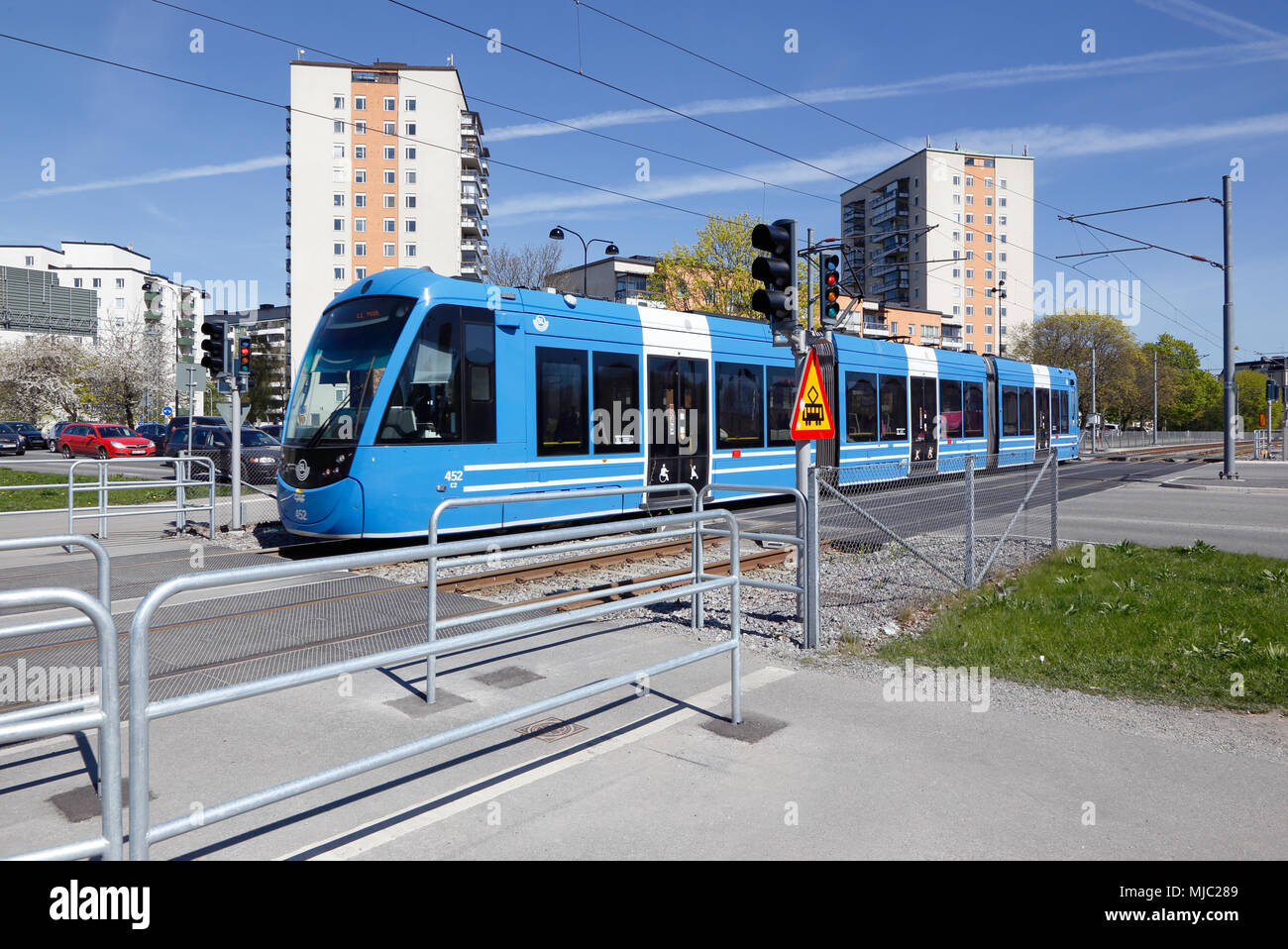 Solna, Schweden - 6. Mai 2016: Blaue Straßenbahn auf dem Tvarbanan Linie an der Kreuzung mit Gransgatan. Stockfoto