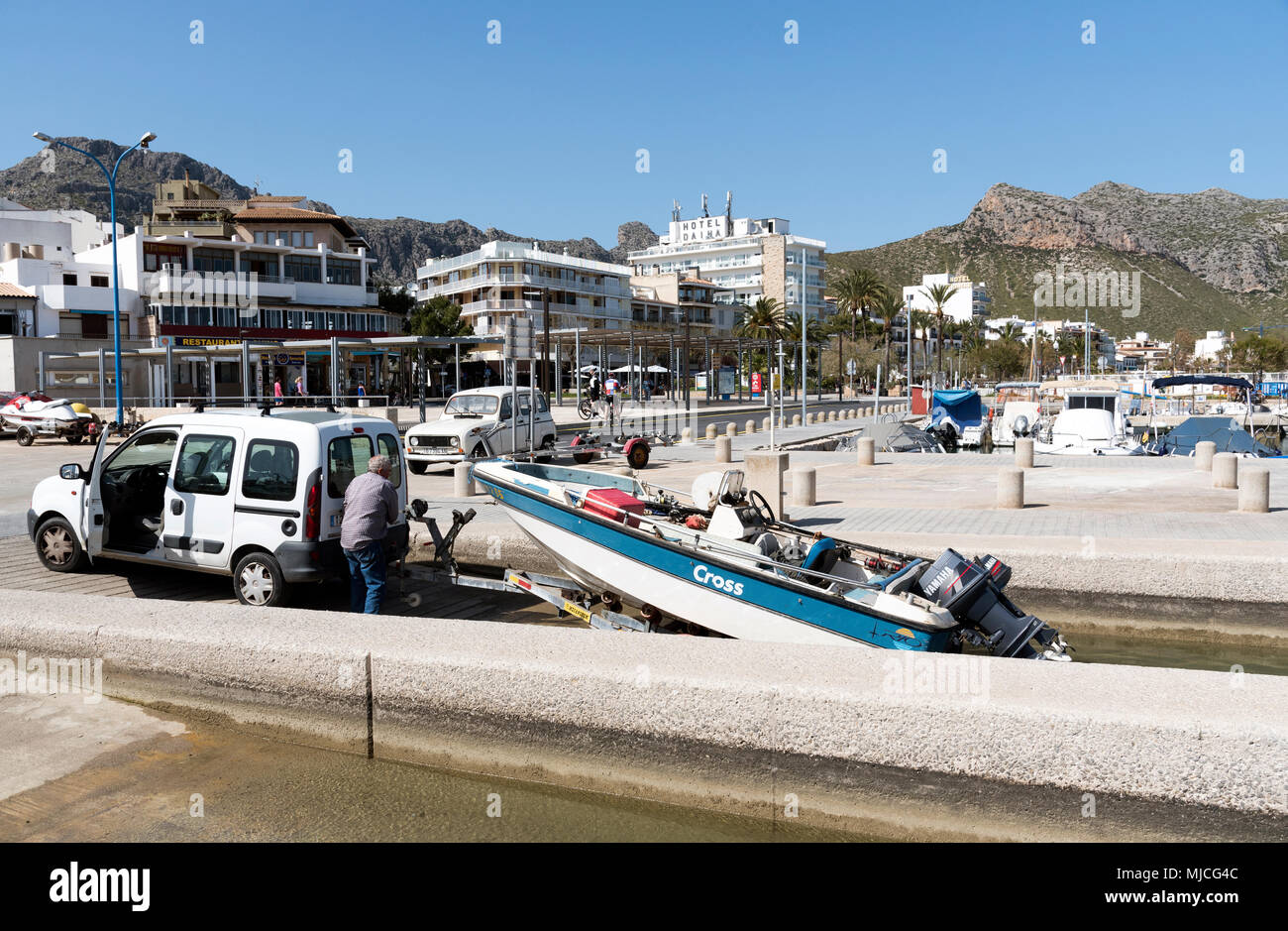 Port de Pollenca, Mallorca, Balearen, Spanien. 2018. Mann winching ein Boot von der Marina in diesem Badeort Porto Pollenca, Mallorca. Stockfoto