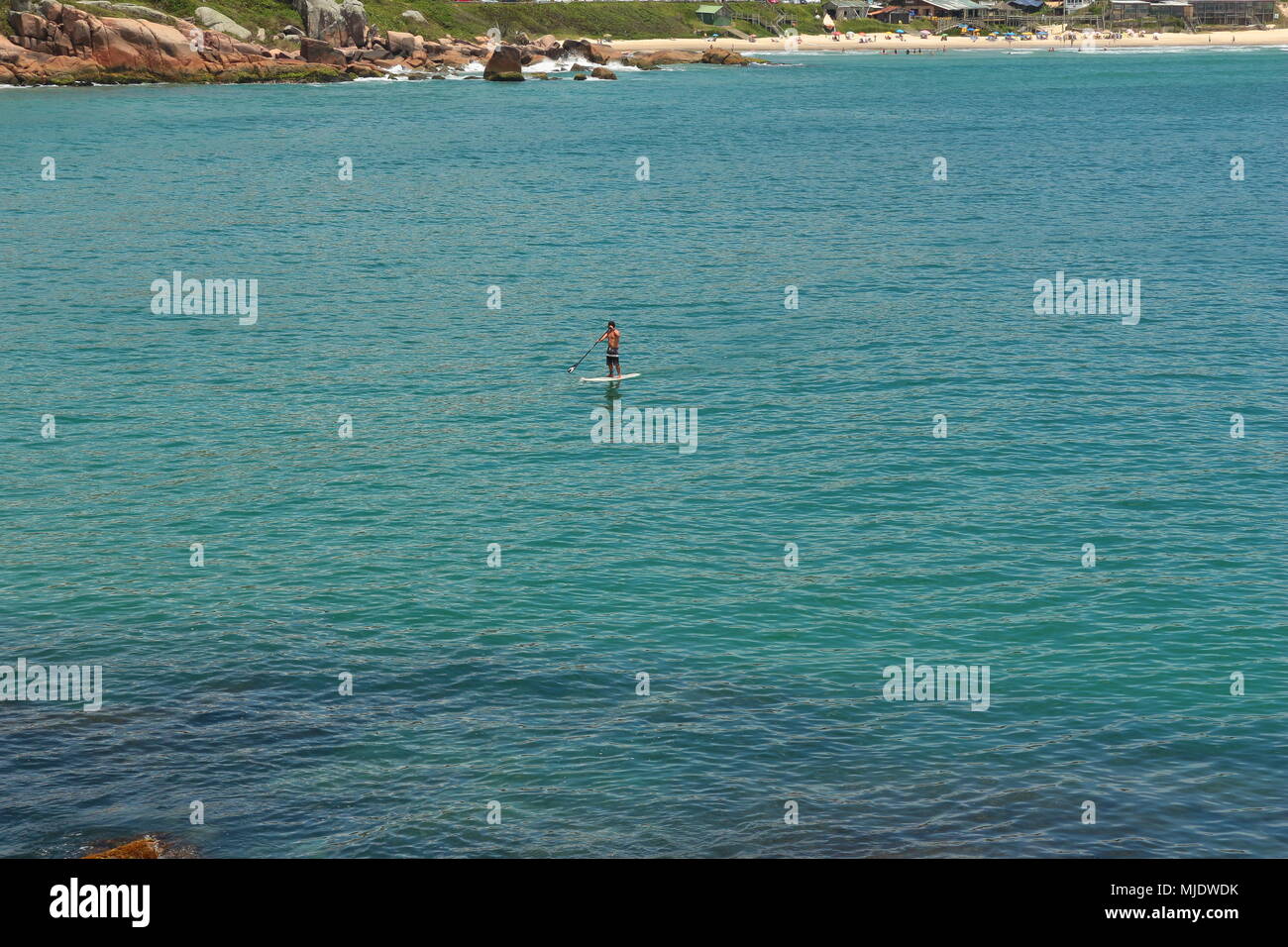 Man Stand up Paddeln im Meer. Praia do Rosa, Brasilien Stockfoto