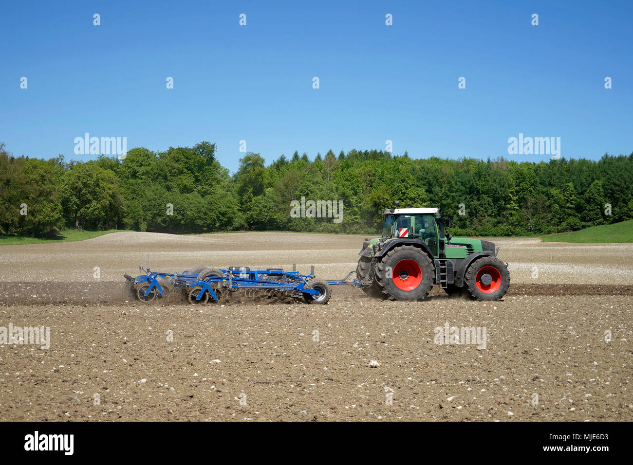 Deutschland, Bayern, Oberbayern, Landwirt, Traktor, Feld, Bodenbearbeitung, Harrow Stockfoto