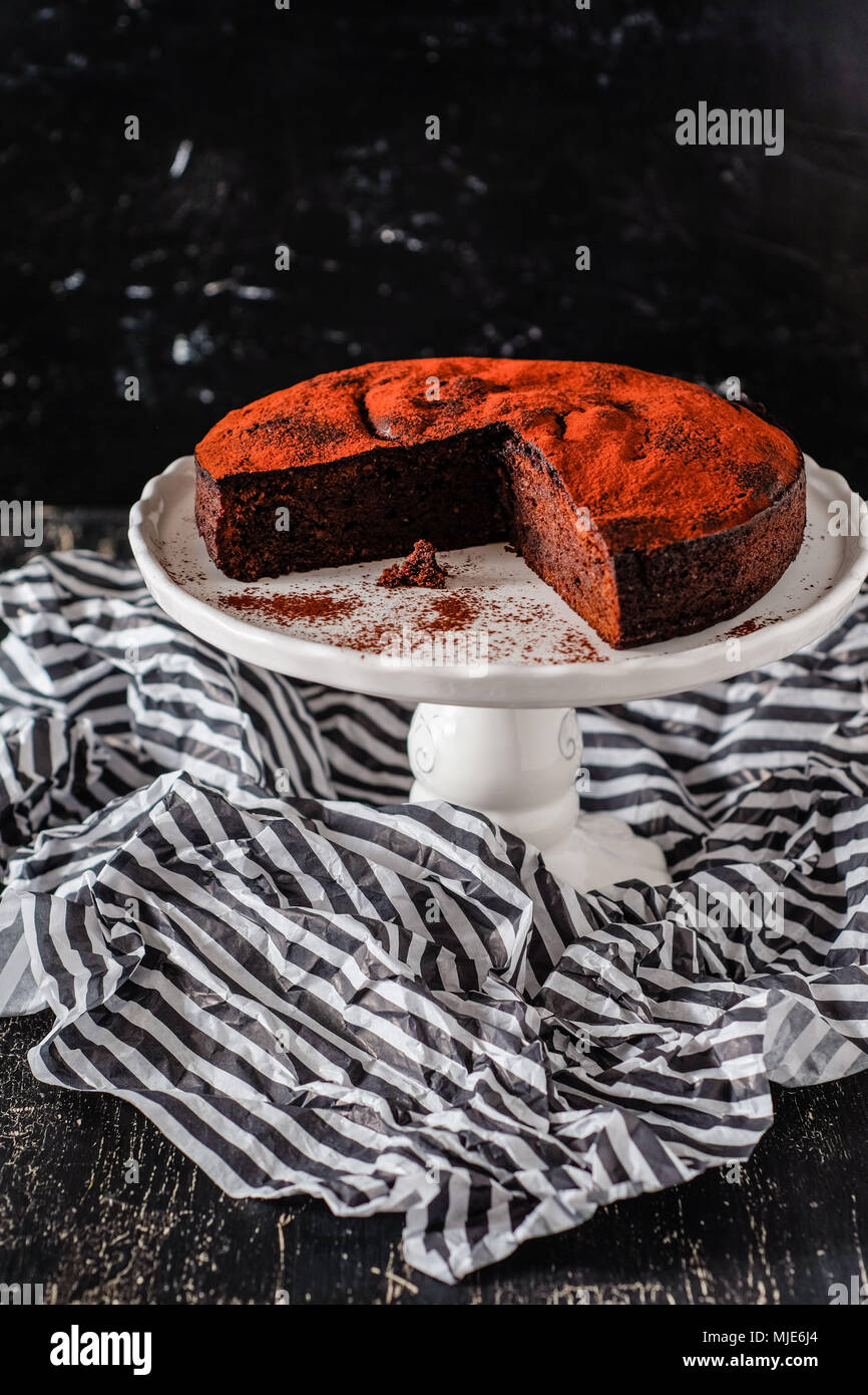 Dunkle Schokolade tarte auf einem weißen Kuchen stehen, Teile davon bereits abgeschaltet Stockfoto