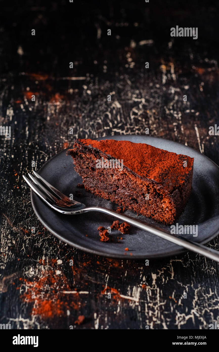 Ein Stück dunkle Paleo Niedrige Carb Schokolade Kuchen auf schwarzem Hintergrund Stockfoto