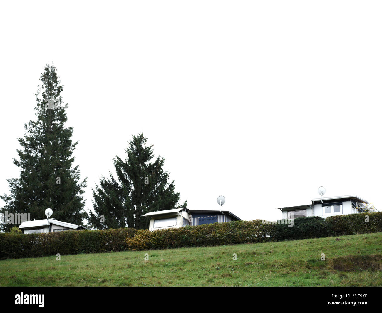 Drei Wohnwagen auf einem Campingplatz, Bäumen, Wiese und Hecke Stockfoto