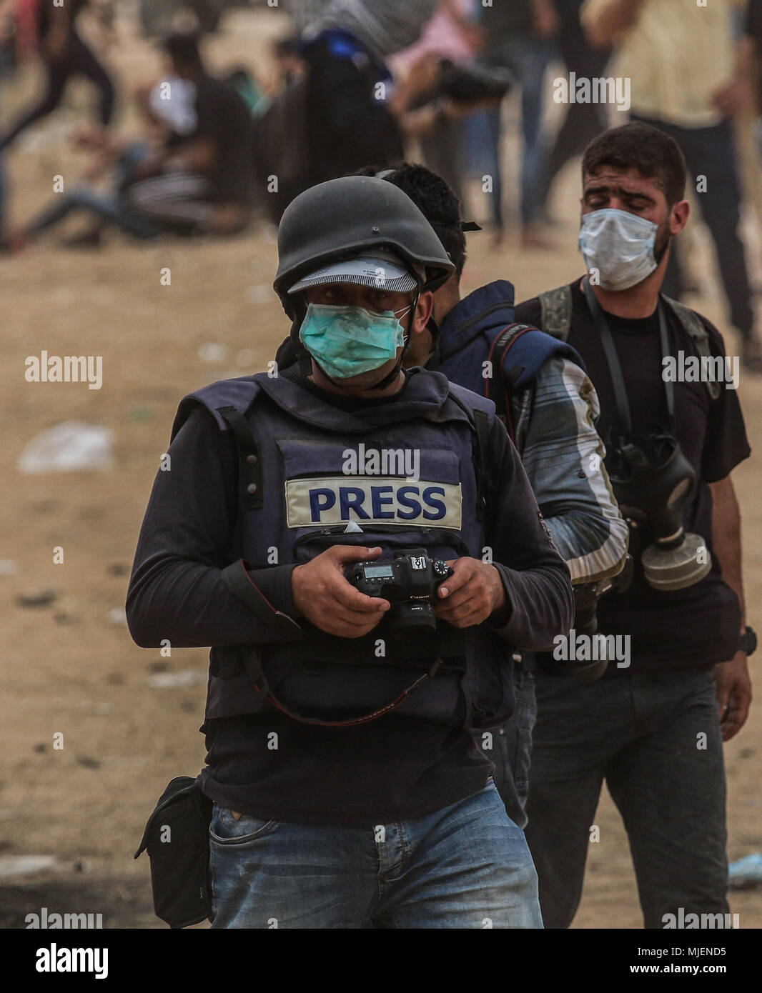 Mai 4, 2018 - Journalisten, die über den Großen März wieder Demonstrationen östlich von Khan Yunis, in der Nähe des Gazastreifens Grenze mit Israel, werden direkt von den Benzinkanister durch die israelische Armee feuerte Tränengas angegriffen. Trotz des Tragens der Kleidung deutlich mit dem Wort drücken Sie die Taste, die Sie als Journalisten und Kameraleute identifizieren gekennzeichnet, palästinensische Journalisten wurden bewusst von israelischen Scharfschützen seit Beginn der großen Demonstration des Zurück Proteste gezielt. Der große Marsch der Rückkehr ist eine Reihe von Massenprotesten entlang der Israel-Gaza Grenze, die am 30. März, um das Recht auf Rückkehr begann Stockfoto