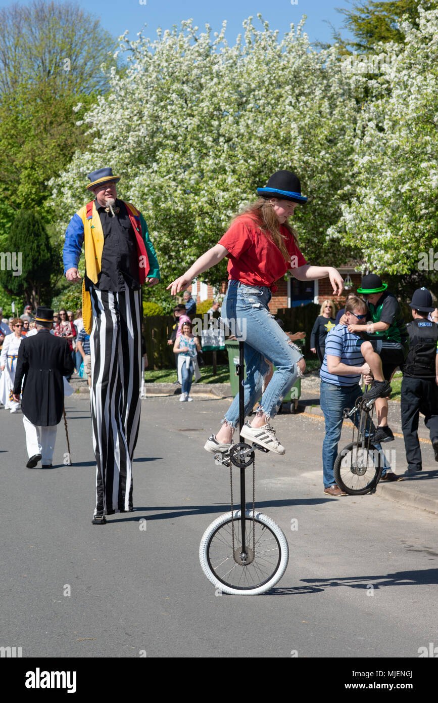 The Borough, Downton, Salisbury, Wiltshire, Großbritannien, 5. Mai 2018. Mayday Feiertag Wochenende Straßenmesse feiert die Ankunft des Frühlings Ein Stelzenläufer und Mono-Radfahrer balancieren in der Parade. Stockfoto