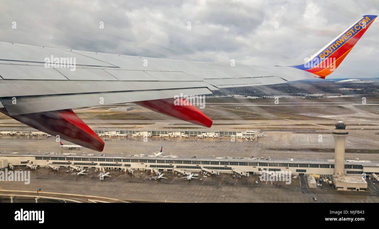 Detroit, Michigan - Southwest Airlines Jet fliegt über den Delta Airlines Terminal wie Blätter Detroit Metro Airport. Stockfoto