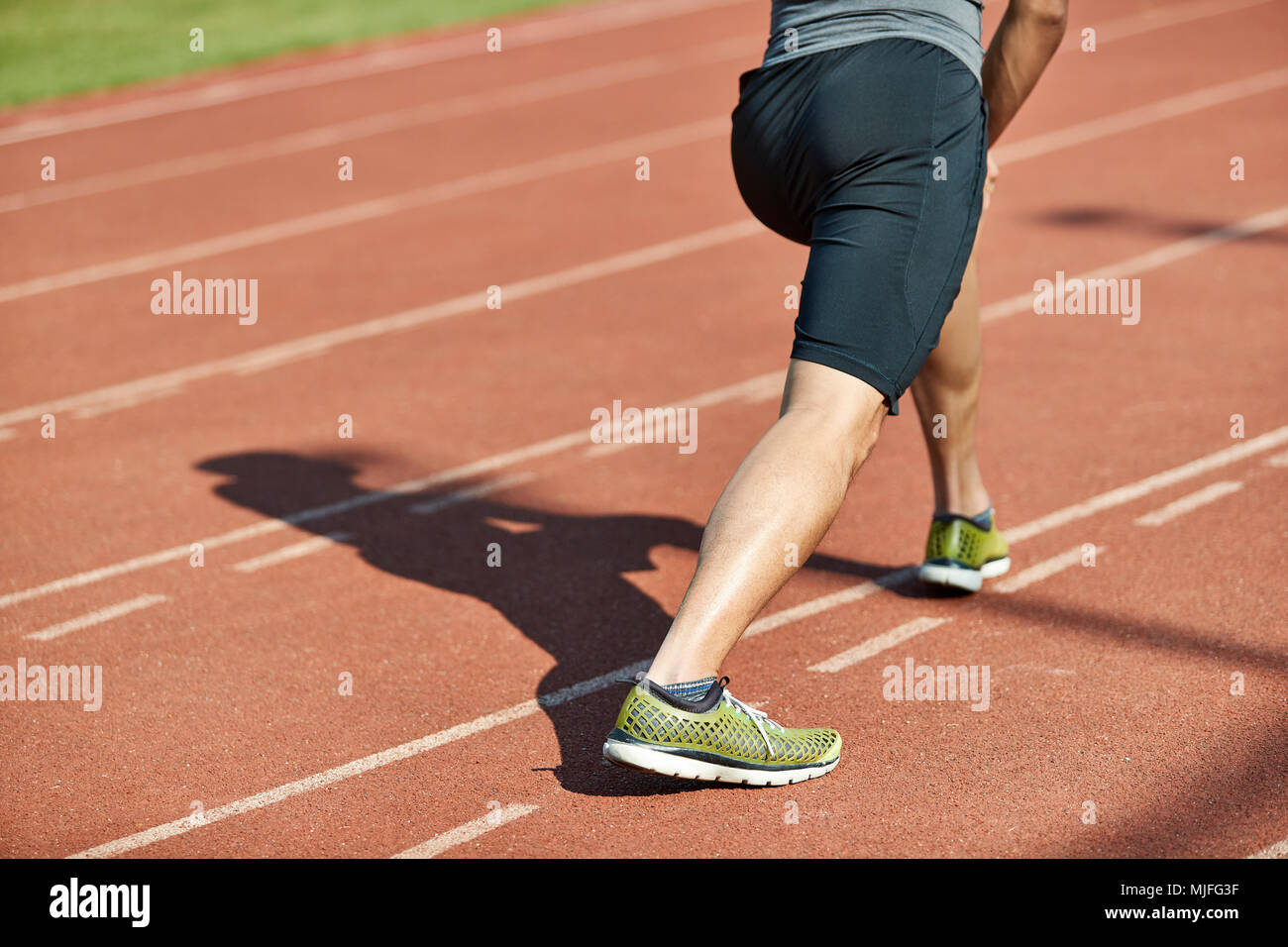 Junge asiatischer Mann-männlichen Athleten Aufwärmen stretching Beine auf Schiene. Stockfoto