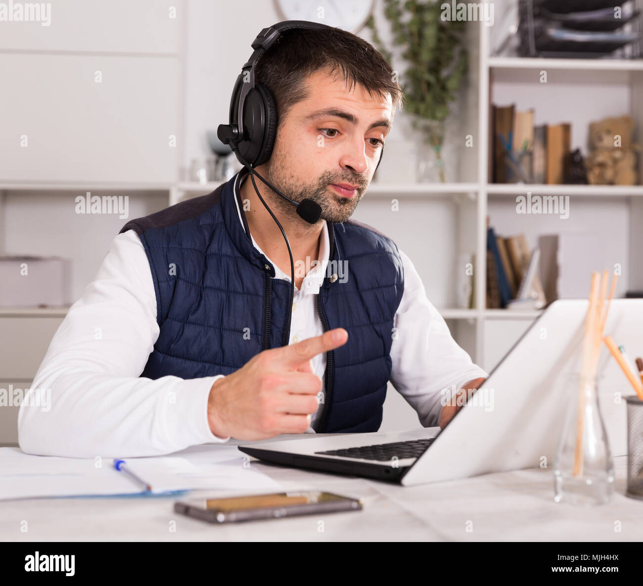 Call Center mann Fahrer mit Headset sprechen mit Client in der Agentur Stockfoto