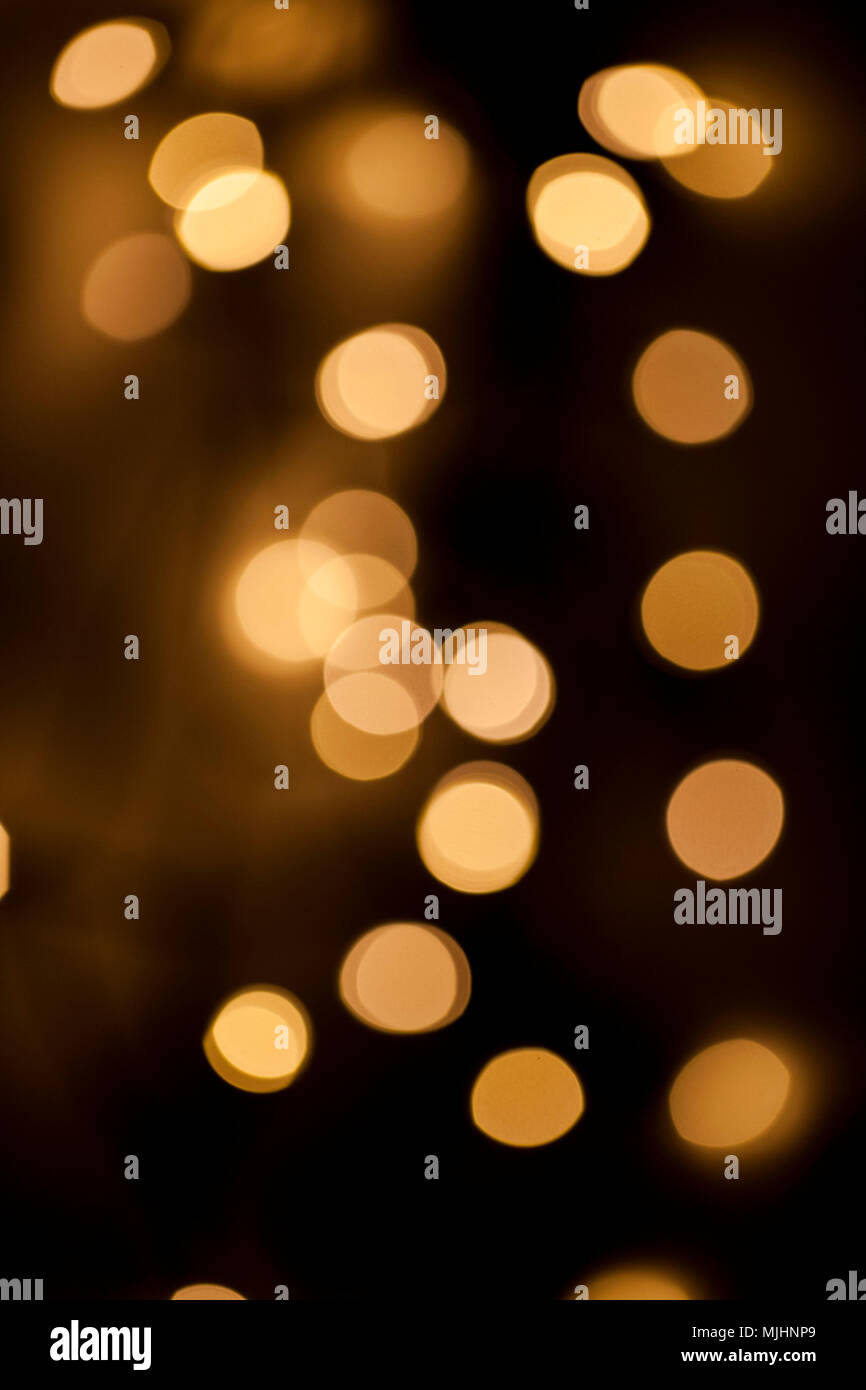 Gelb leuchtende und glitzernde Blasen auf schwarzem Hintergrund Stockfoto