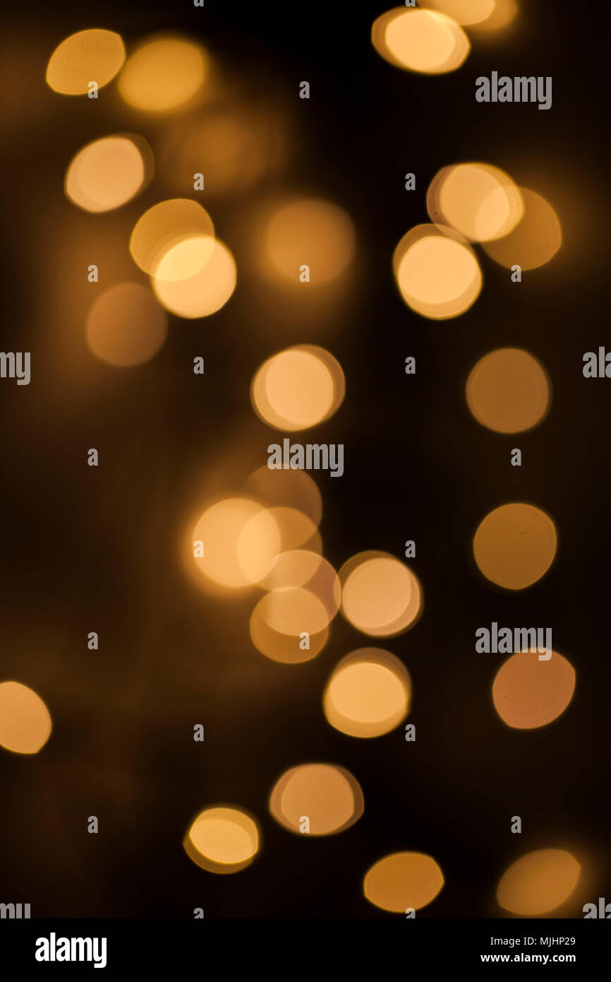 Gelb leuchtende und glitzernde Blasen auf schwarzem Hintergrund Stockfoto