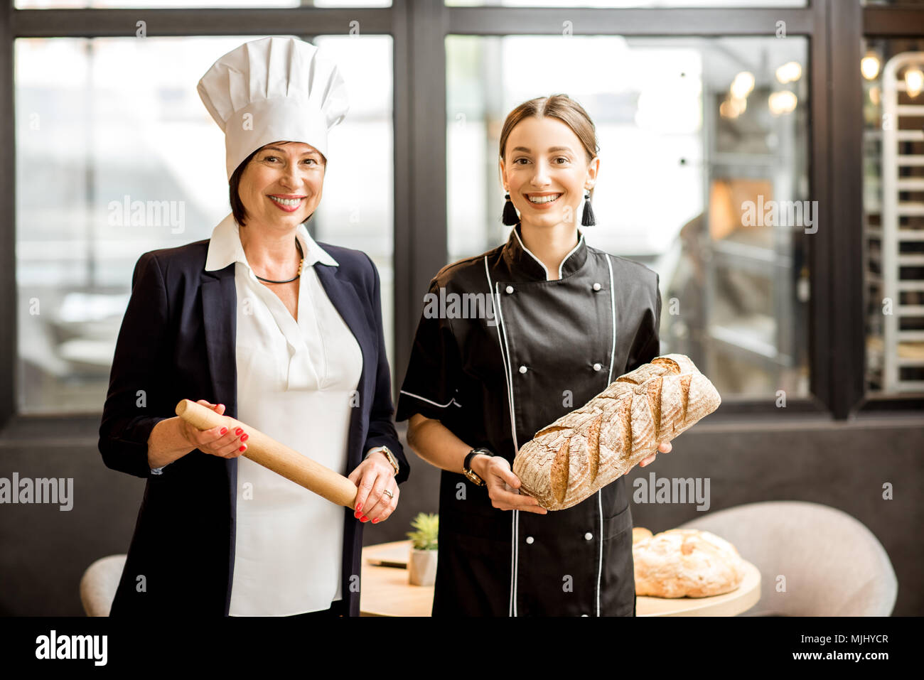 Senior Chef Konditor mit jungen Assistenten in der Bäckerei Stockfoto