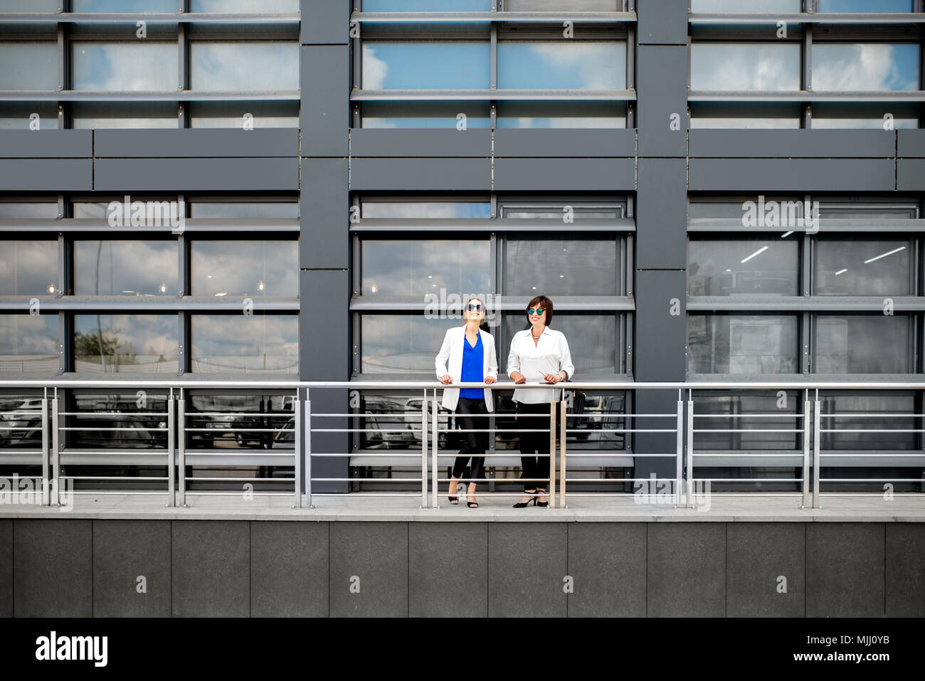 Die Leute stehen in der Nähe der modernen Fassade Hintergrund Stockfoto