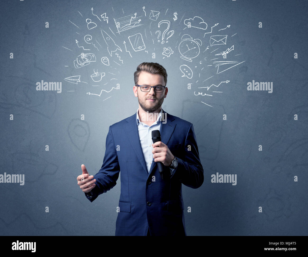 Geschäftsmann sprechen in das Mikrofon mit gemischten Doodles über seinem Kopf Stockfoto