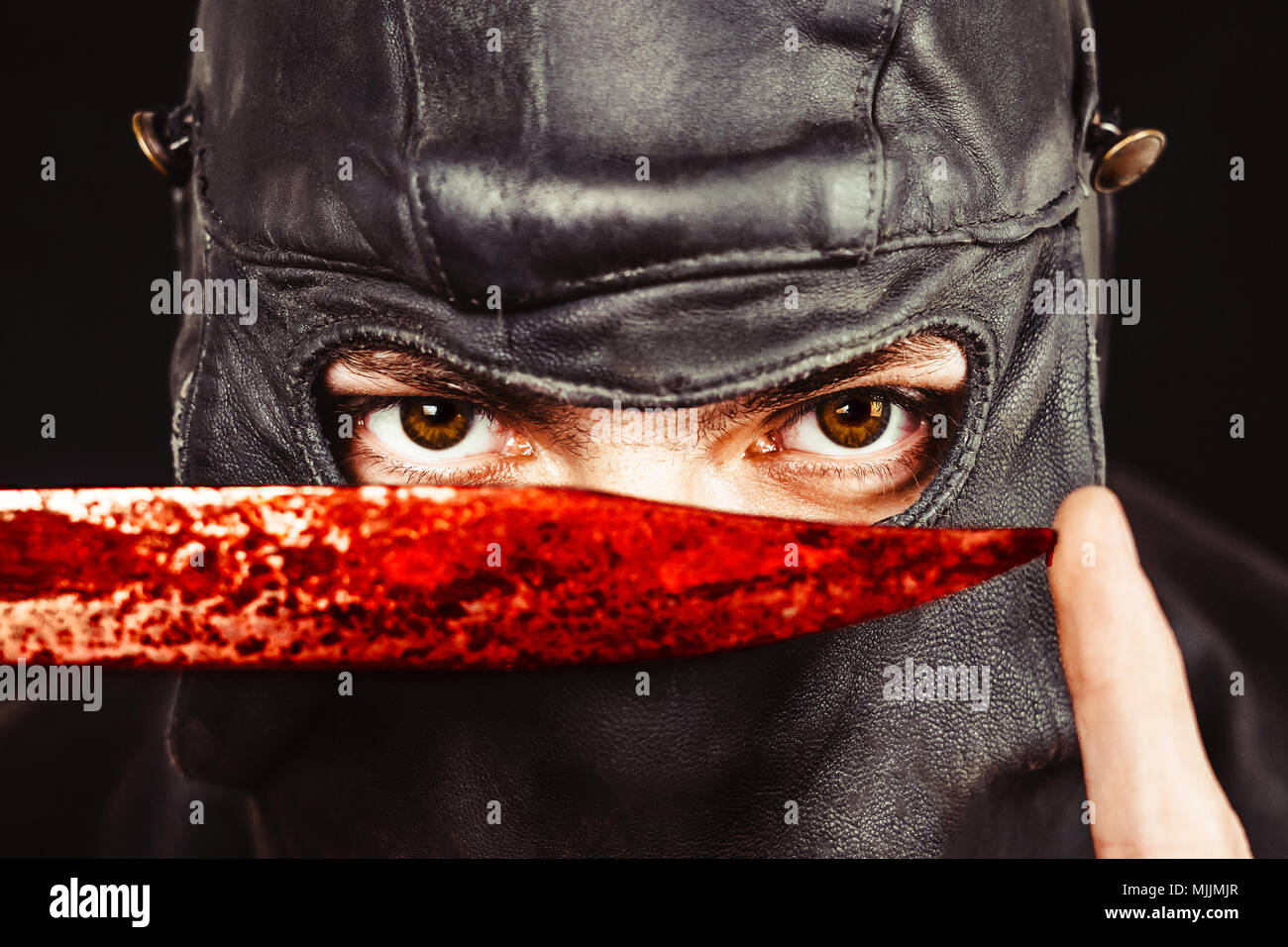 Terrorist in einem Leder Maske mit einem Messer Stockfoto