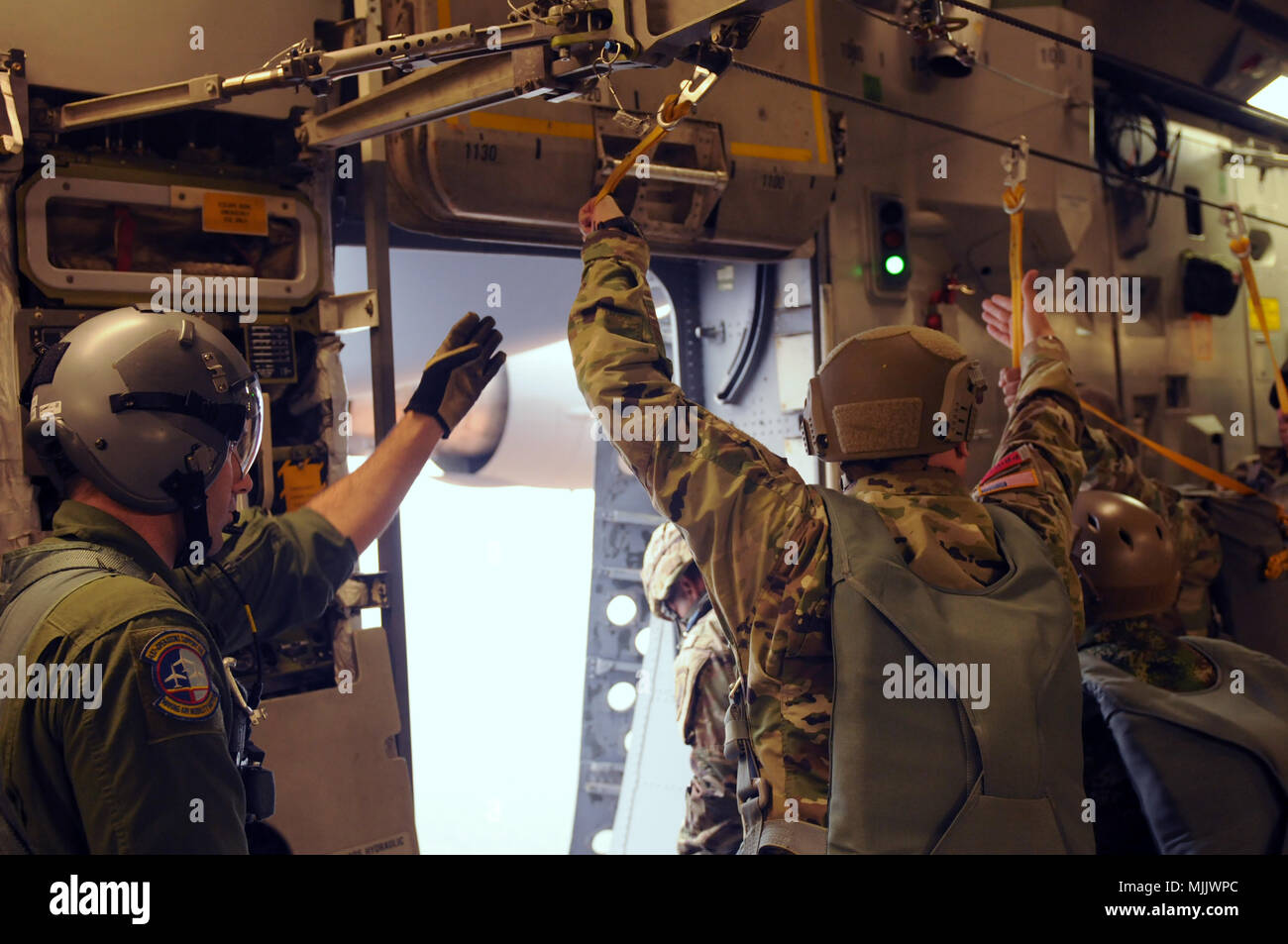 Us Air Force MSgt. Daniel S. Carlisle, weist auf das grüne Licht an Bord einer C-17 GlobemasterIII während des 20. jährlichen Randy Oler Memorial Betrieb Spielzeug Drop Dez 2, 2017. Betrieb Spielzeug Drop ist der weltweit größte kombinierten Betrieb mit acht Partner nation Fallschirmjäger teilnehmenden und Soldaten erlaubt, die Möglichkeit, auf ihren militärischen beruflichen Spezialgebiet zu trainieren, pflegen ihre Bereitschaft, in die Luft und wieder zurück in die lokale Gemeinschaft zu geben. (U.S. Armee Foto von Sgt. Nicole Paese) Stockfoto