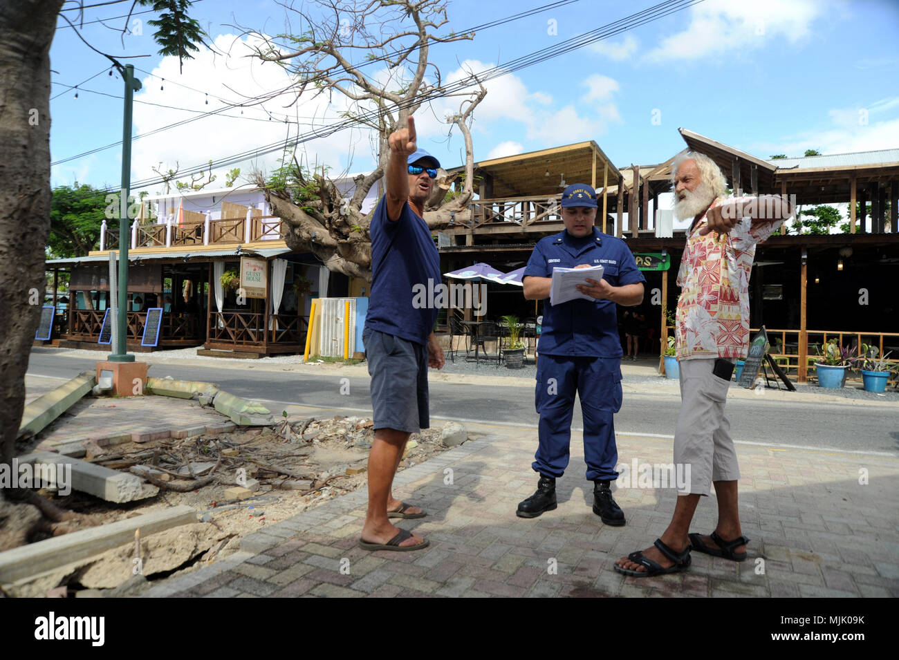 Coast Guard Petty Officer 3rd Class Jonathan Centeno, mit dem Hurrikan Maria ESF-10 Puerto Rico Antwort, Gespräche mit Eigentümern von Ron Solt und Bruno Weckert, in einer Bemühung, Besitzer der Boote gestrandeten aus dem Hurrikan zu identifizieren und Ihnen eine kostenlose Möglichkeit, ihre Behälter entnommen, Vieques, Puerto Rico, Dez. 4, 2017 zu unterrichten. Die Schiffseigner in Puerto Rico kann der Hurrikan Maria Schiff Hotline unter (786) 521-3900 einen Umzug planen, fordern Sie kostenlose Unterstützung aus dem ESF-10 Unified command ein Schiff zu entfernen, oder ein Schiff, das bereits entfernt wurde. (U.S. Coast Guard Foto von Pet Stockfoto