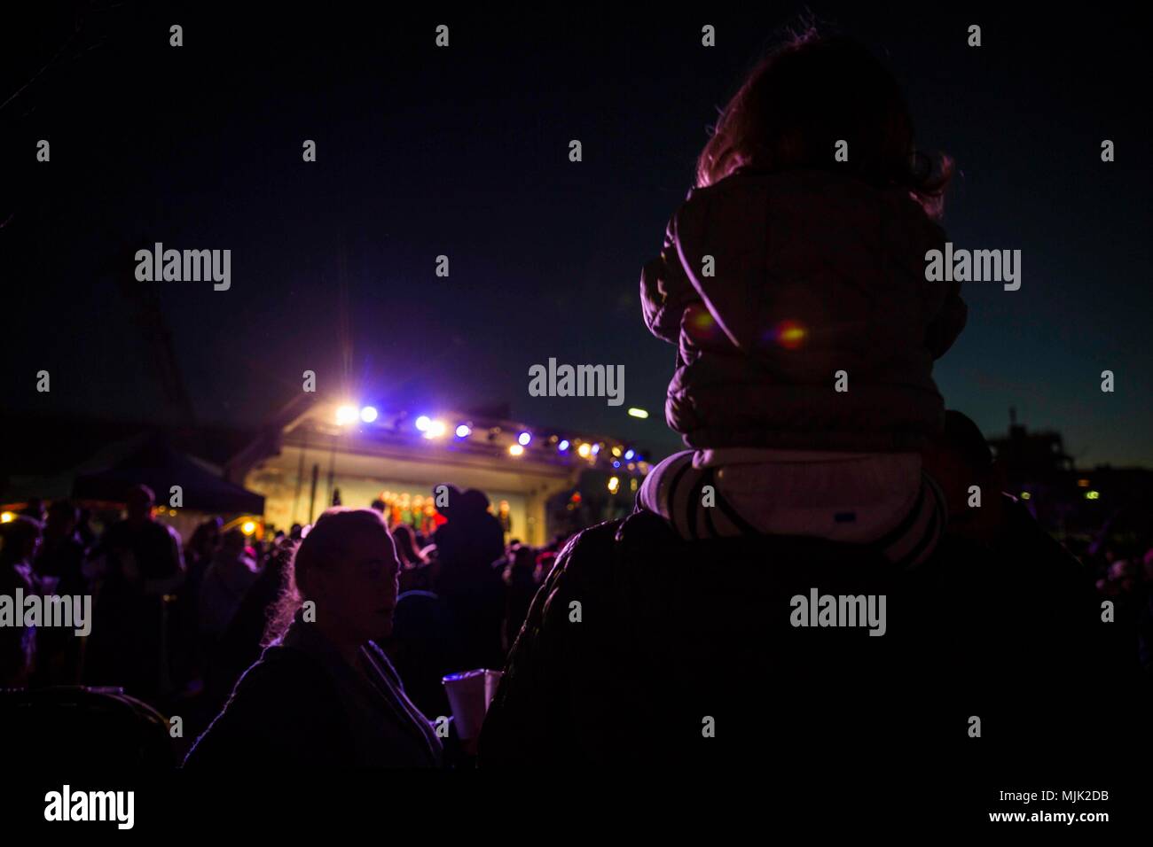 Die Weihnachtsbaumbeleuchtung auf der Marine Corps Air Station Iwakuni war eine saisonale Veranstaltung, bei der US-Mitarbeiter und japanische Einwohner am 2. Dezember 2017 zusammenkamen. Das Archivbild dokumentiert einen Navy Flight Sanitäter der Marine Aerial Refueler Transport Squadron 152, der mit einem Kind während des Installationschorprogramms anwesend war. Stockfoto