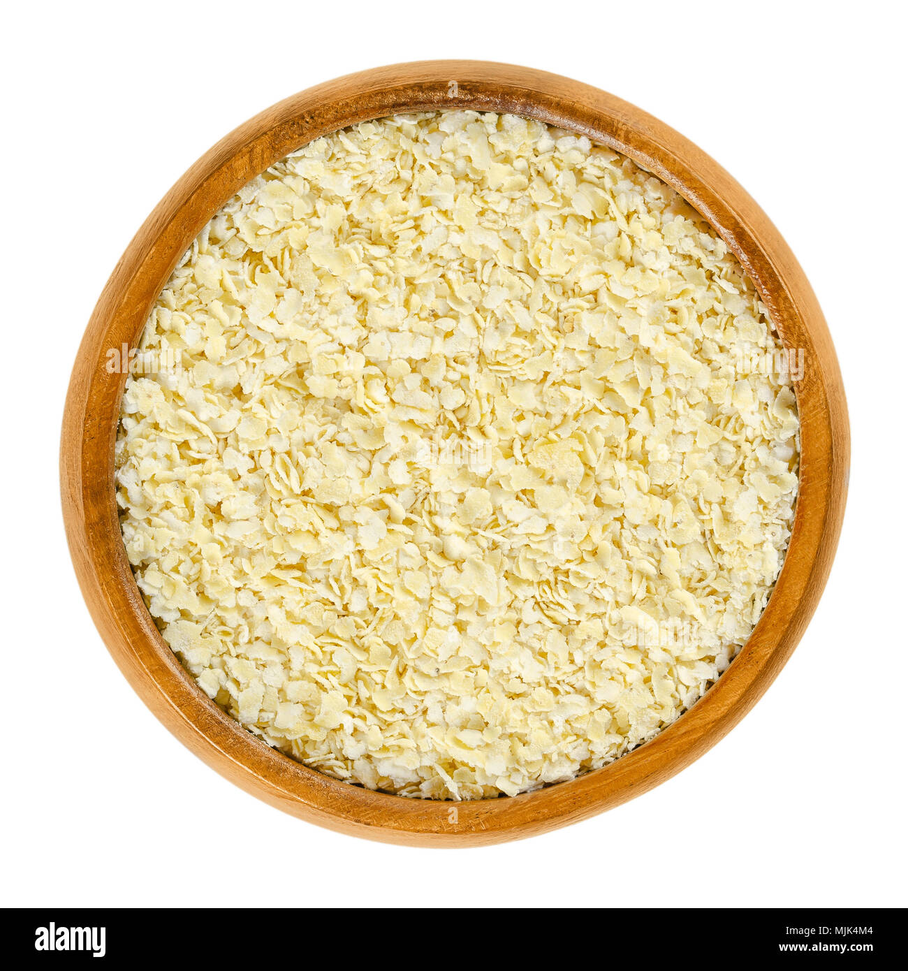 Hirse Flocken in Houten. Licht, gelbe Hirse, gerollt für Haferbrei, Müsli und Backen verwendet. Weizen- und glutenfreie Getreide. Isolierte Makro Foto. Stockfoto