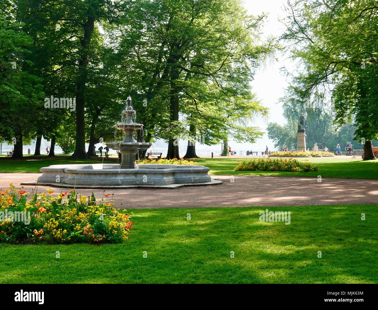 Blühende Frühling Blumen vor einem friedlichen Brunnen, am See in der Altstadt von Annecy, Frankreich Stockfoto