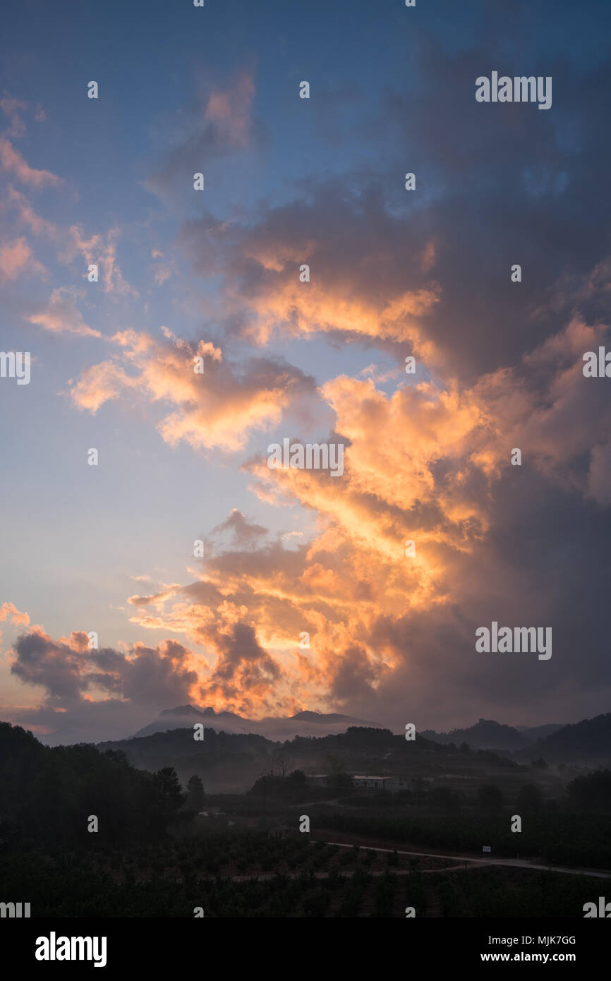 Fantastische Farben in den Wolken als Sonne über spanische Berge und die Landschaft. Stockfoto