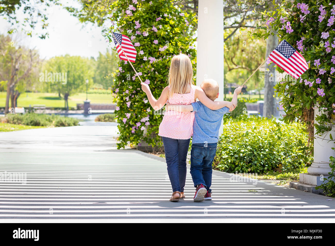 Junge Schwester und Bruder Winken amerikanische Flaggen in den Park. Stockfoto