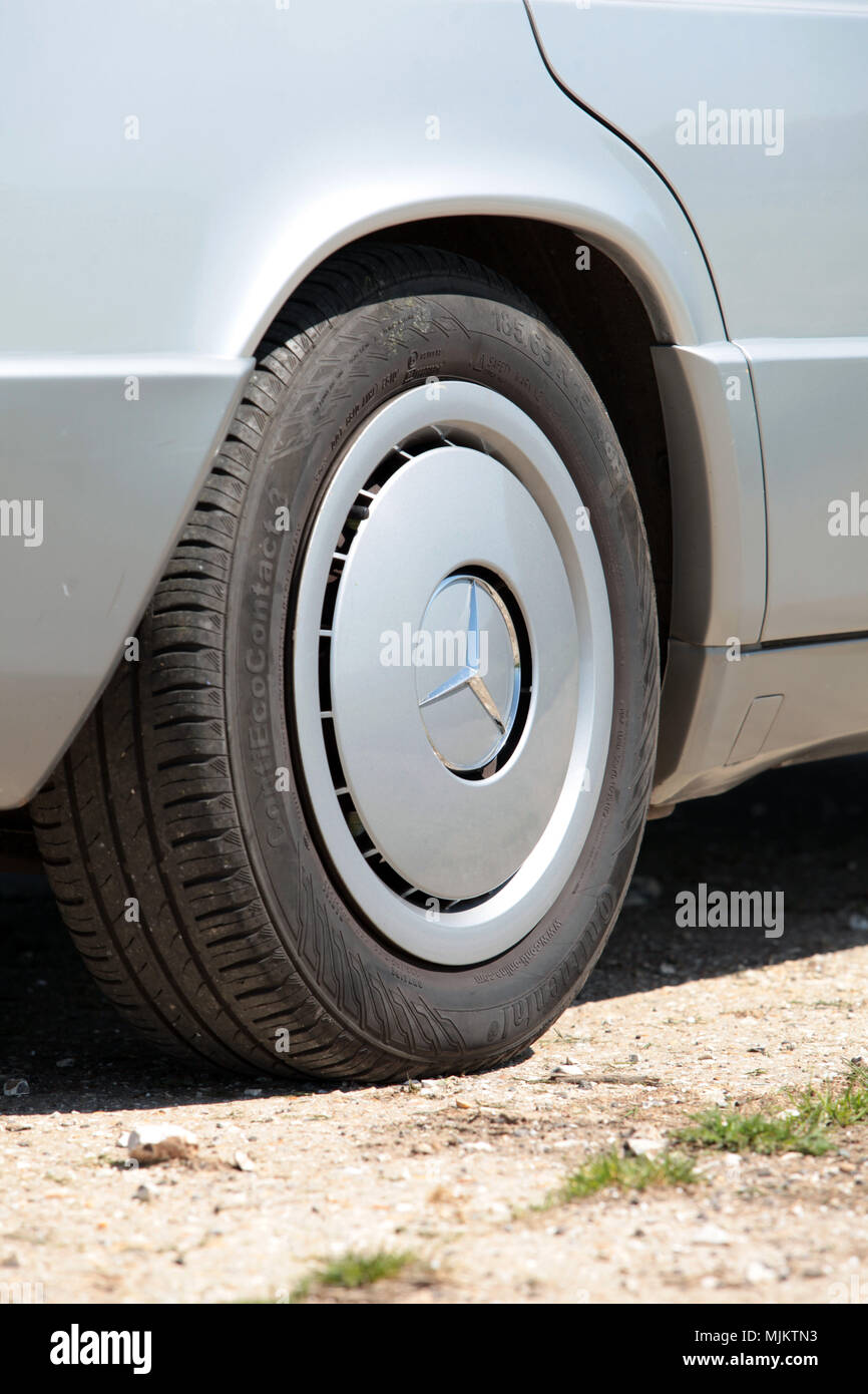 Nahaufnahme eines standard Hinterrad und Verkleidung eines 1993 Mercedes Benz 190e in Großbritannien 2018 genommen. Stockfoto