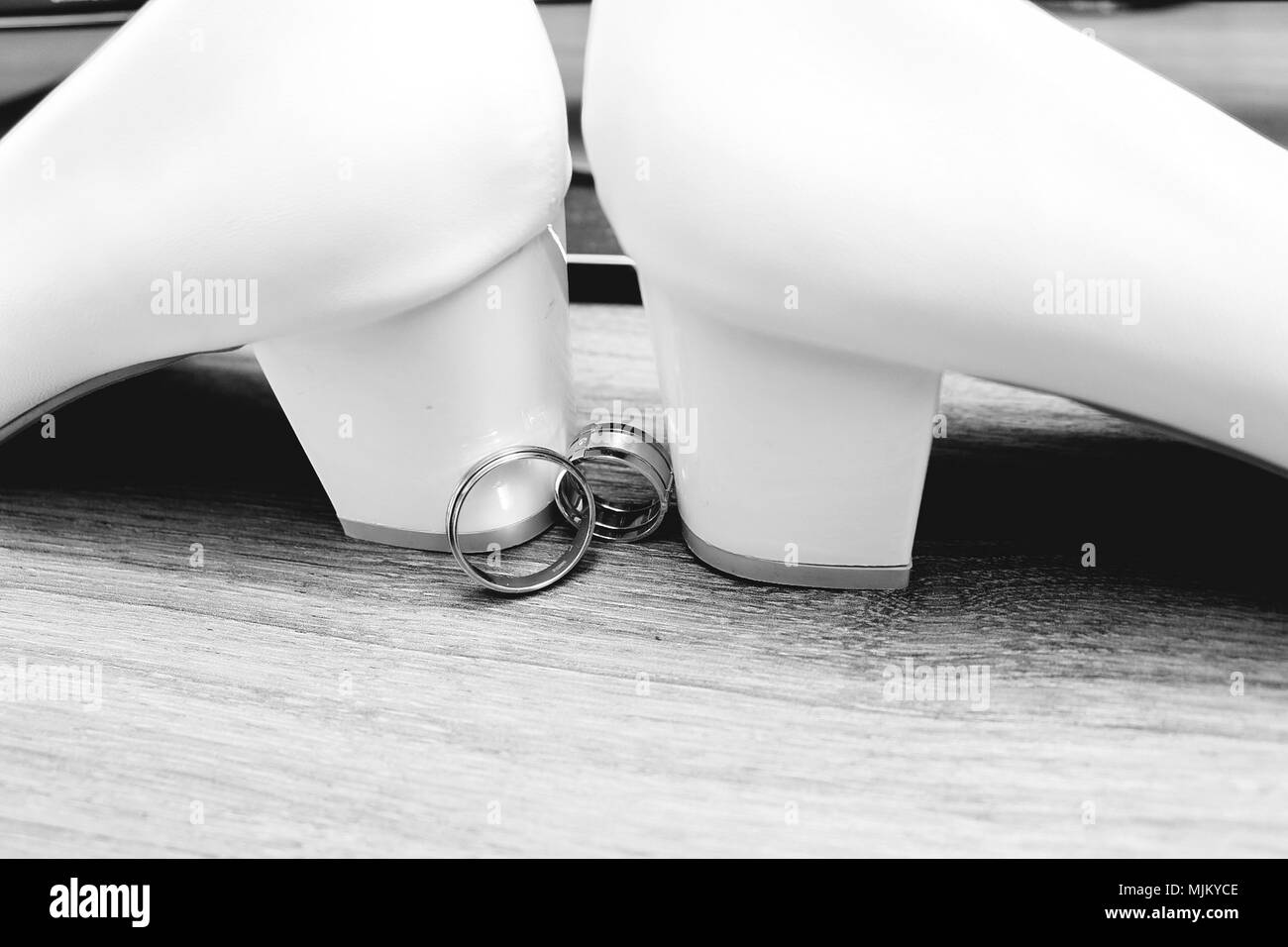Hochzeit. Dekor. Der Braut Schuhe, eine schöne Hochzeit Bouquet, Ringe, Anstecker und Schmuck schön auf einem grauen Hintergrund Holz gelegt werden. Nach oben V Stockfoto