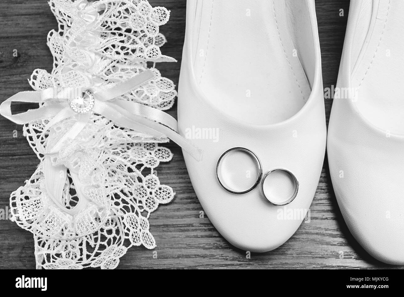 Hochzeit. Dekor. Der Braut Schuhe, eine schöne Hochzeit Bouquet, Ringe, Anstecker und Schmuck schön auf einem grauen Hintergrund Holz gelegt werden. Nach oben V Stockfoto