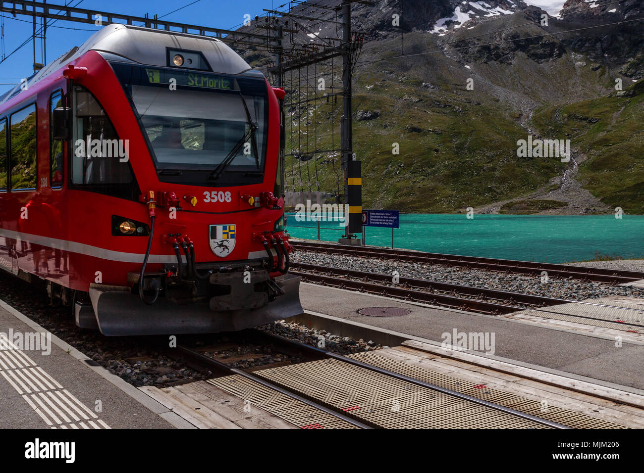 Poschiavo, Graubünden, Schweiz - 10 AUGUST 2016: Rote Zug der Rhätischen Bahn in die Station Ospizio Bernina auf 2253 m an einem sonnigen Tag in Stockfoto