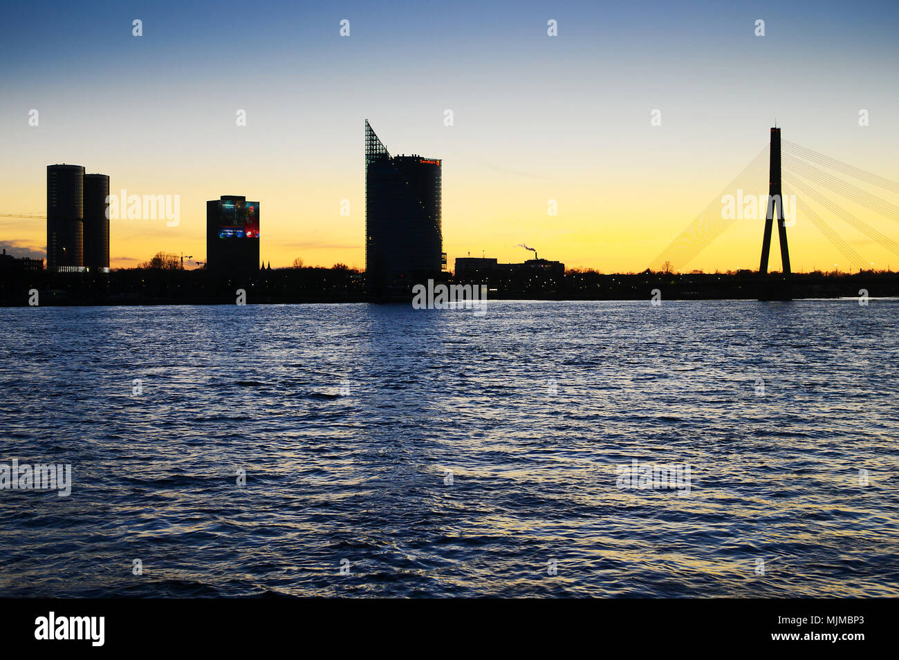 Riga, Lettland. Nacht Panorama von Riga. Wolkenkratzer Silhouetten und Fluss Daugava, westlichen Dwina, bei Sonnenuntergang. Stockfoto