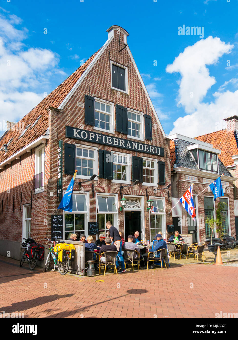 Die Menschen genießen Sie Getränke und Snacks an der Terrasse des Café in der historischen Altstadt von Dokkum, Friesland, Niederlande Stockfoto