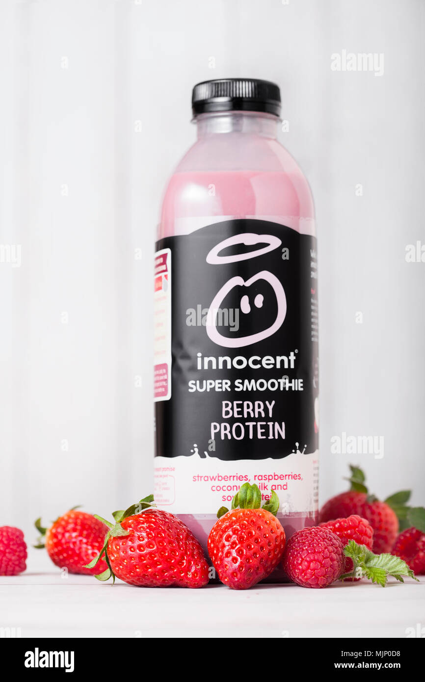 LONDON, Großbritannien - 03.Mai 2018: die Flasche von Unschuldigen Beeren smoothie Fruchtdrink mit Vitaminen auf Holzuntergrund mit frischen Beeren. Stockfoto