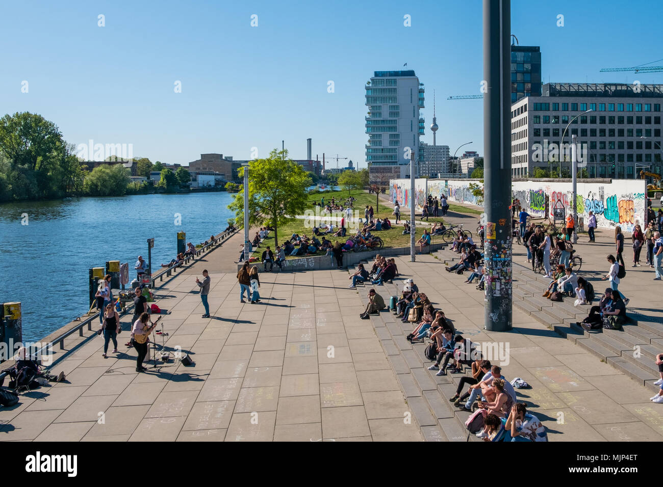 Berlin, Deutschland - Mai, 2018: Viele Leute an der Spree an der Berliner Mauer (East Side Gallery) an einem sonnigen Tag in Berlin, Deutschland Stockfoto
