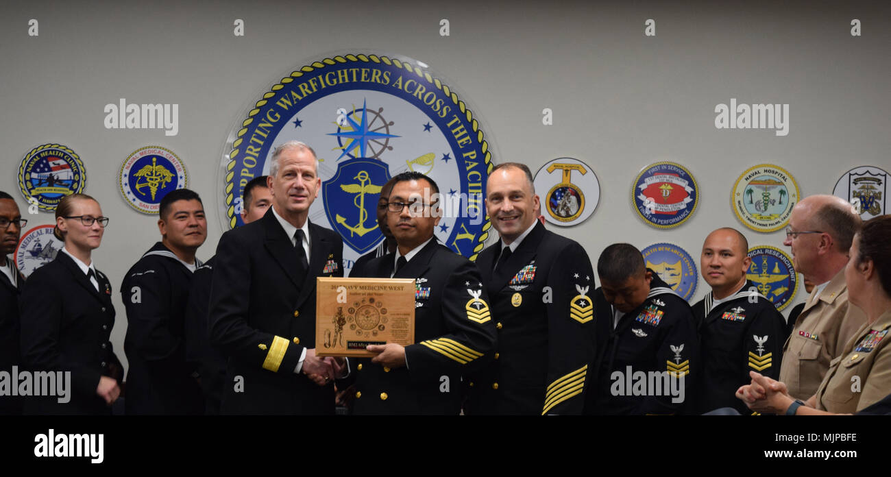 171214-N-KR 394-090 SAN DIEGO, Kalifornien (31. 14, 2017) HMCM Norman Delacruz, interim Command Master Chief für U.S. Naval Hospital Yokosuka (vorne Mitte), erhält den 2017 Marine Medizin West Segler des Jahres (Soja) Auszeichnung im Namen von Hospital Corpsman 2. Klasse Afiyah Bradshaw. Hintere Adm. Paul Pearigen (vorne links), Commander, Marine Medizin West und Chef der Marine Medical Corps, und CMCDCM Loren Rucker, Command Master Chief für Marine Medizin West (vorne rechts), überreichte den Preis an die Marine Medizin West Sitz in einem Konferenzraum, der 14 nominierten (hintere Reihe), die wir im Lieferumfang enthalten Stockfoto