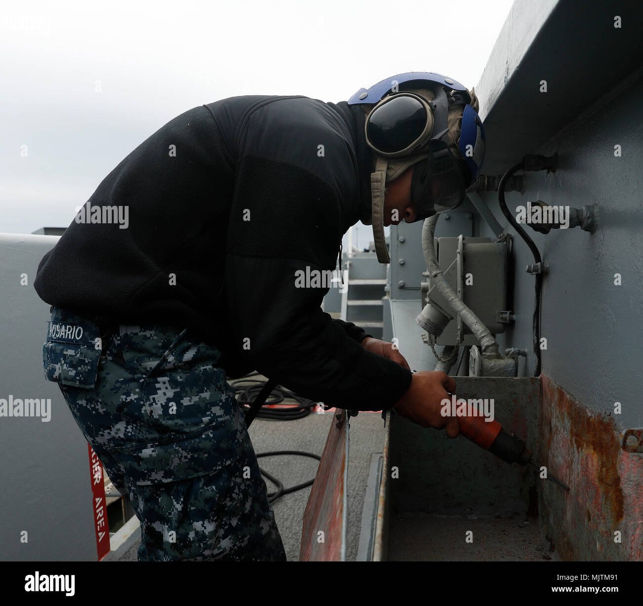 171222-N-EN 275-0027 NORFOLK (31. 22, 2017) Flieger Jeter Rosario needleguns Korrosion auf der Bulk-Kopf unter das Flight Deck der Nimitz-Klasse Flugzeugträger USS Abraham Lincoln (CVN 72). (U.S. Marine Foto von Mass Communication Specialist 3. Klasse Jacob Smith/Freigegeben) Stockfoto