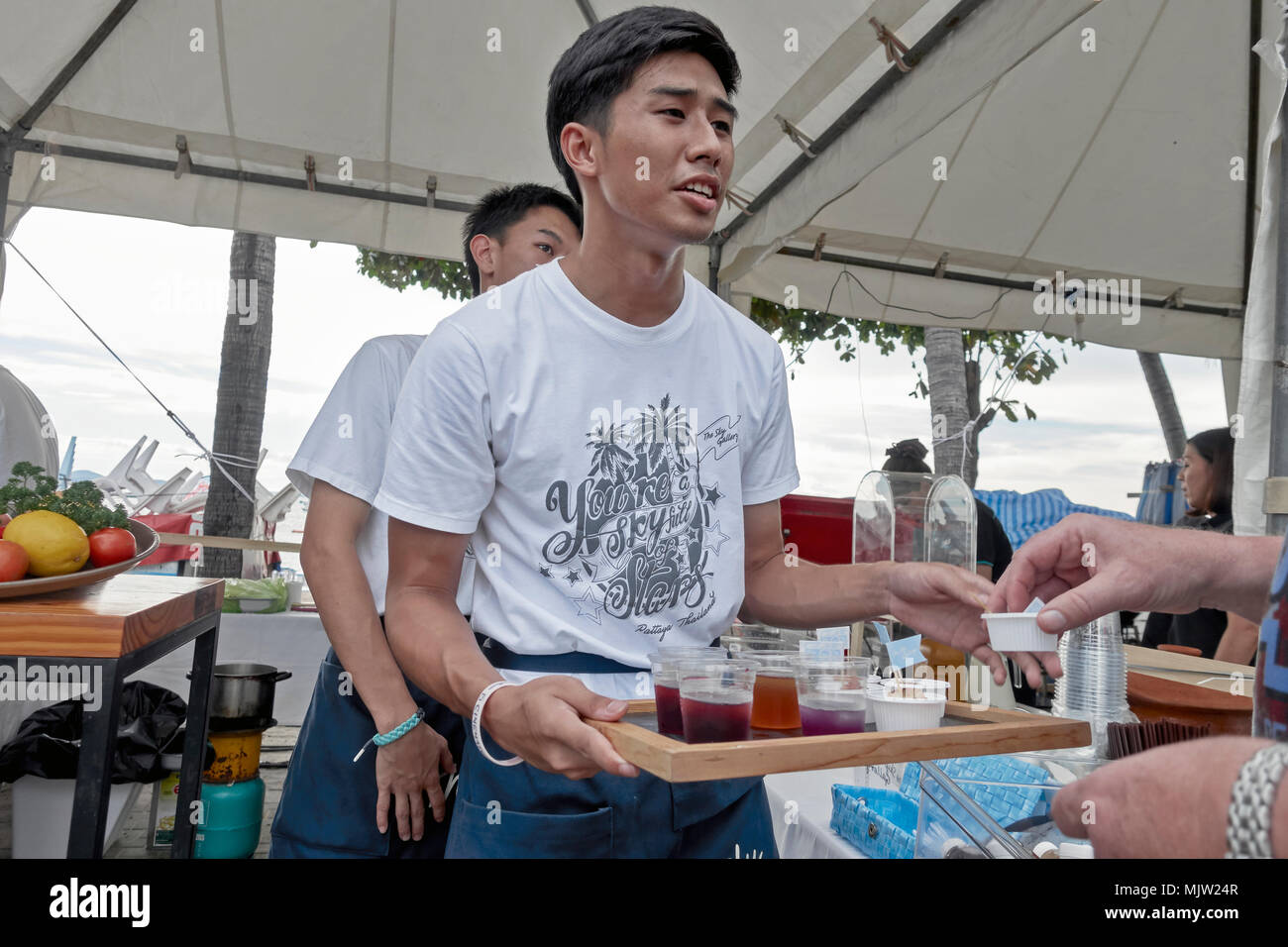Kellner serviert kostenloses Getränk Verkoster vor einem Festival. Pattaya, Thailand, Südostasien Stockfoto