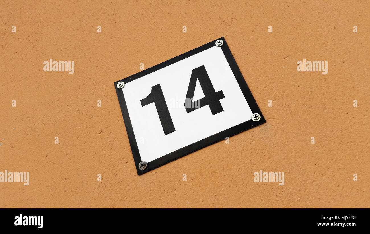 Eine Hausnummer Schild mit der Nummer 14 auf einem braunen Wand isoliert. Stockfoto
