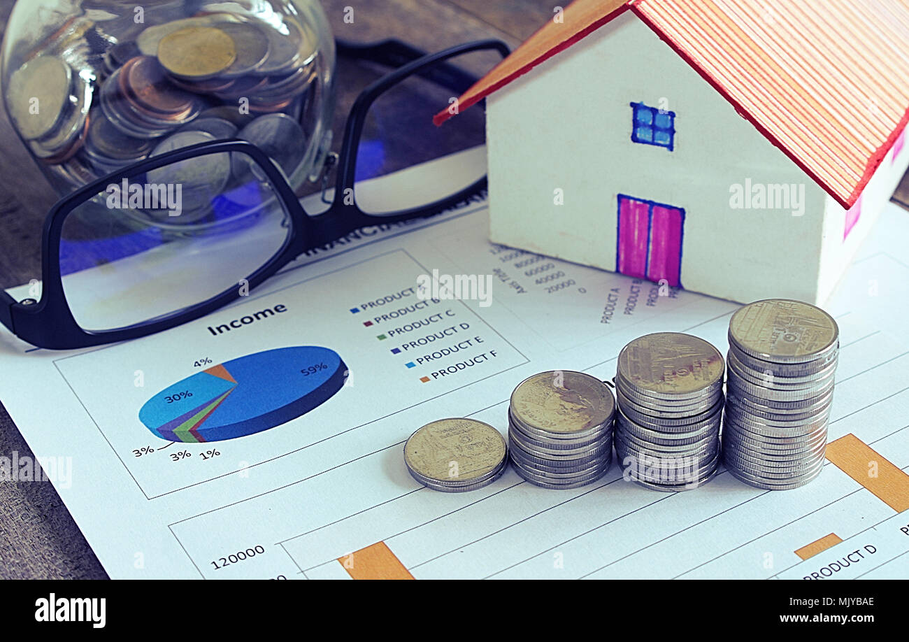 Haus Modell und Buch Bankkonto und coin stack und Einnahmen. Stockfoto