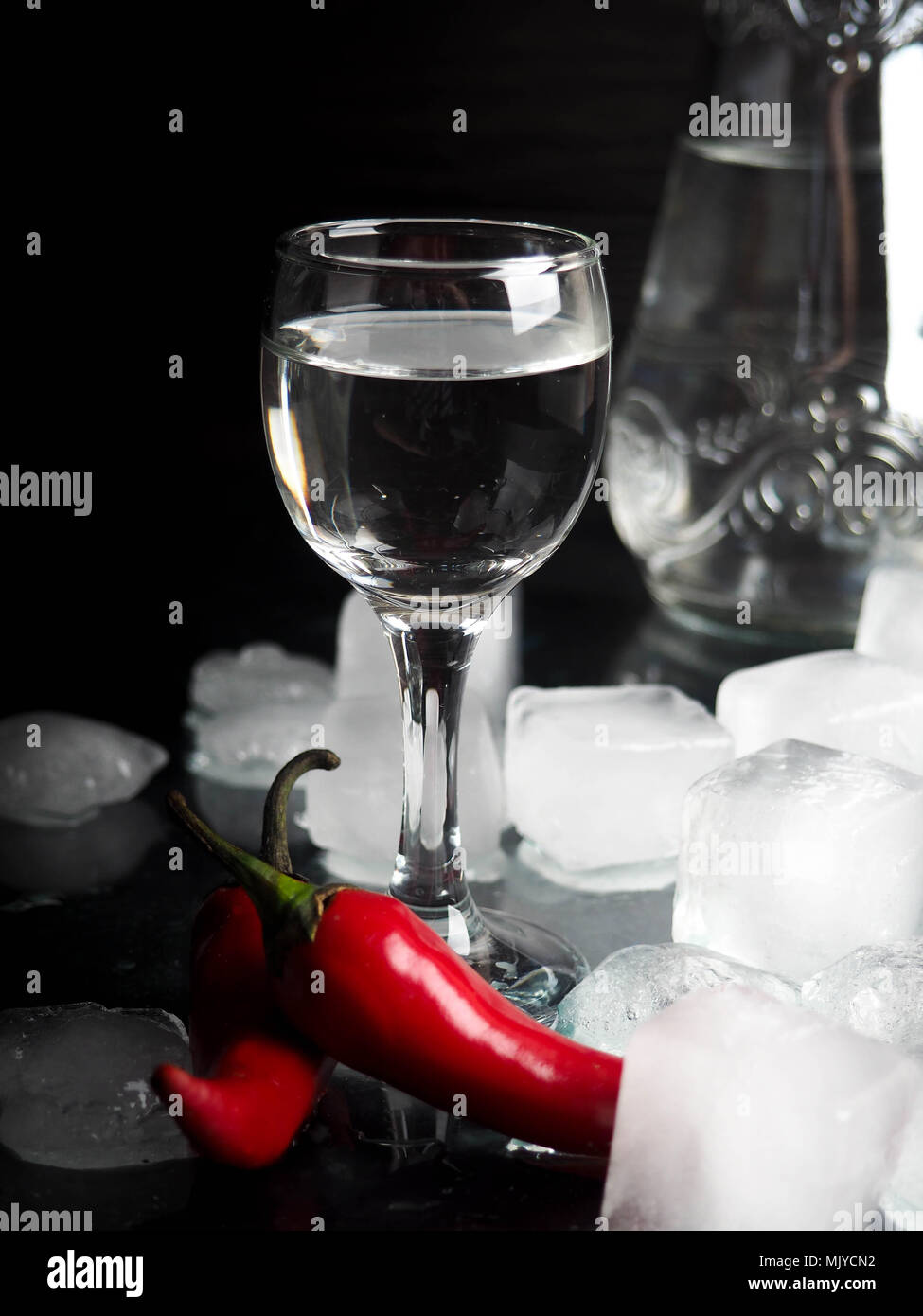 Mit einem Schuss Wodka, ein alkoholisches Getränk, Eis, Feuer, Eis, roter Chili Pfeffer. Das Konzept der Alkohol, Spirituosen. Stockfoto