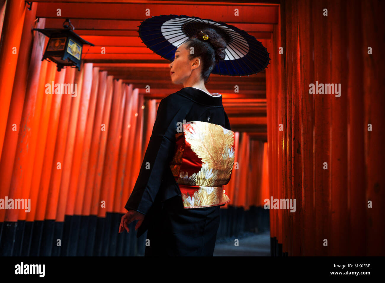 Asiatische Frau in der traditionellen japanischen Kimonos an Fushimi Inari Schrein in Kyoto, Japan Stockfoto