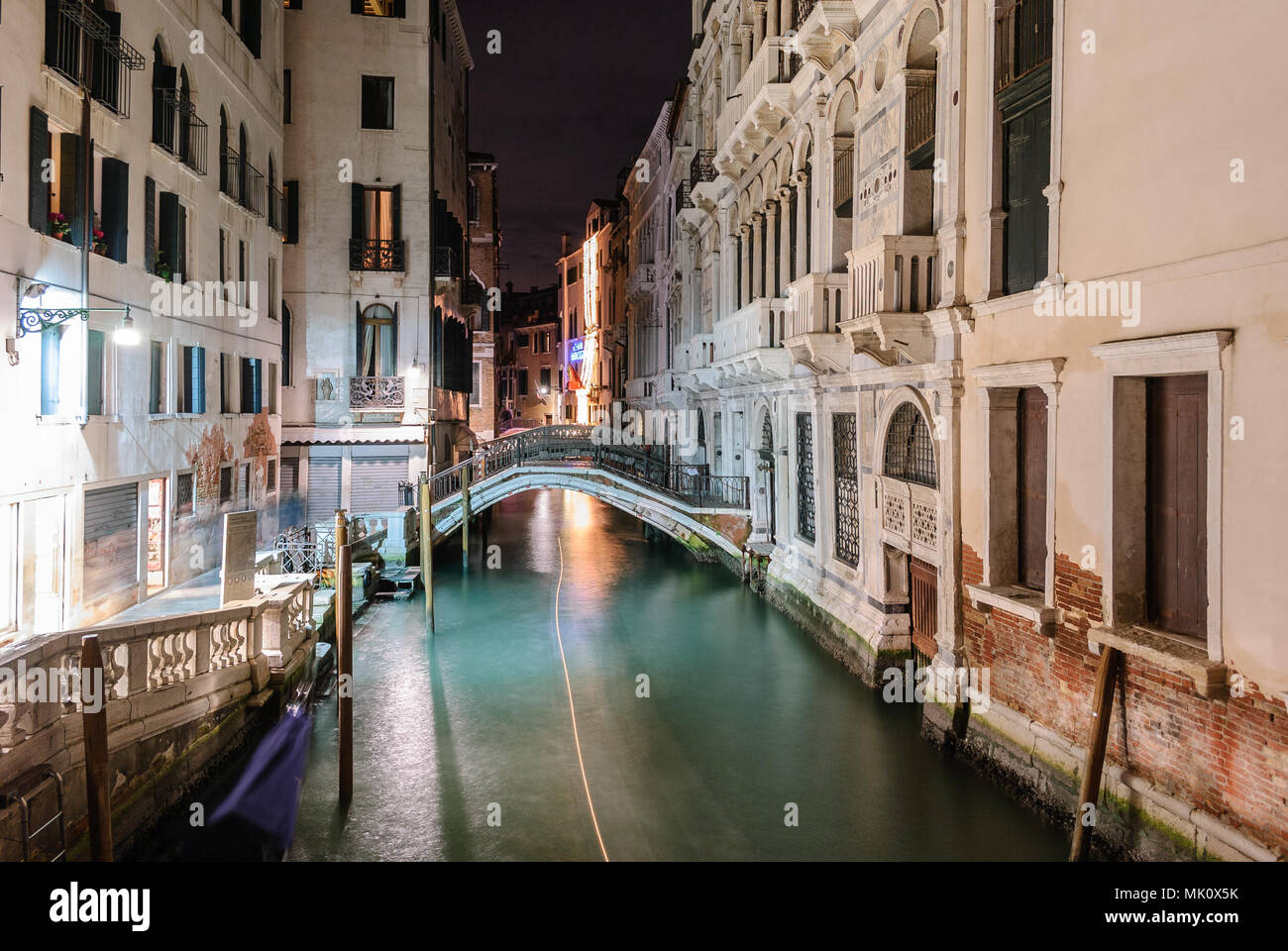 Nacht Blick auf einen typischen Kanal in Venedig mit dem Licht weg von einem Boot Stockfoto